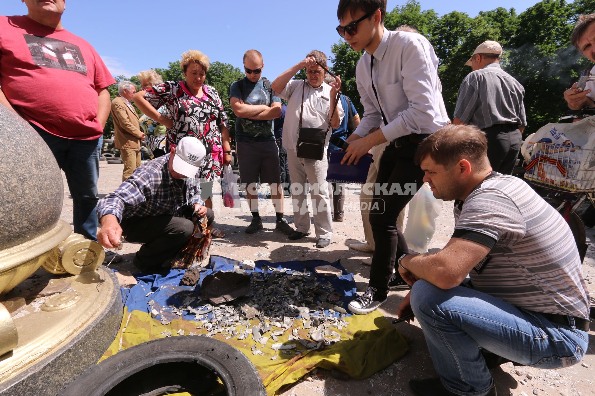 Луганск. Здание Луганской областной администрации после авианалета украинской армии. На снимке: люди собирают осколки снарядов на украинский флаг.