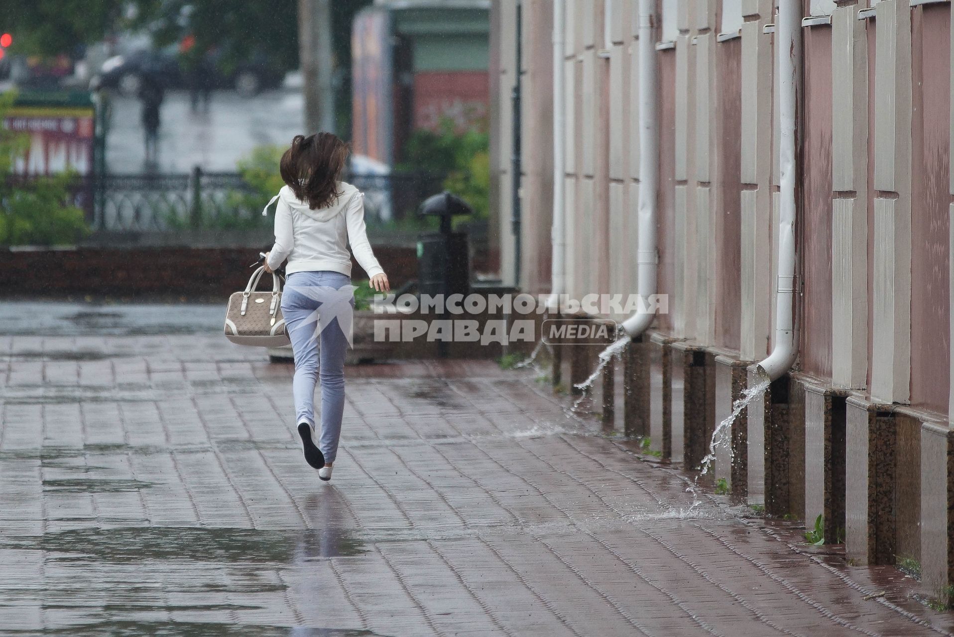Девушка бежит под дождем