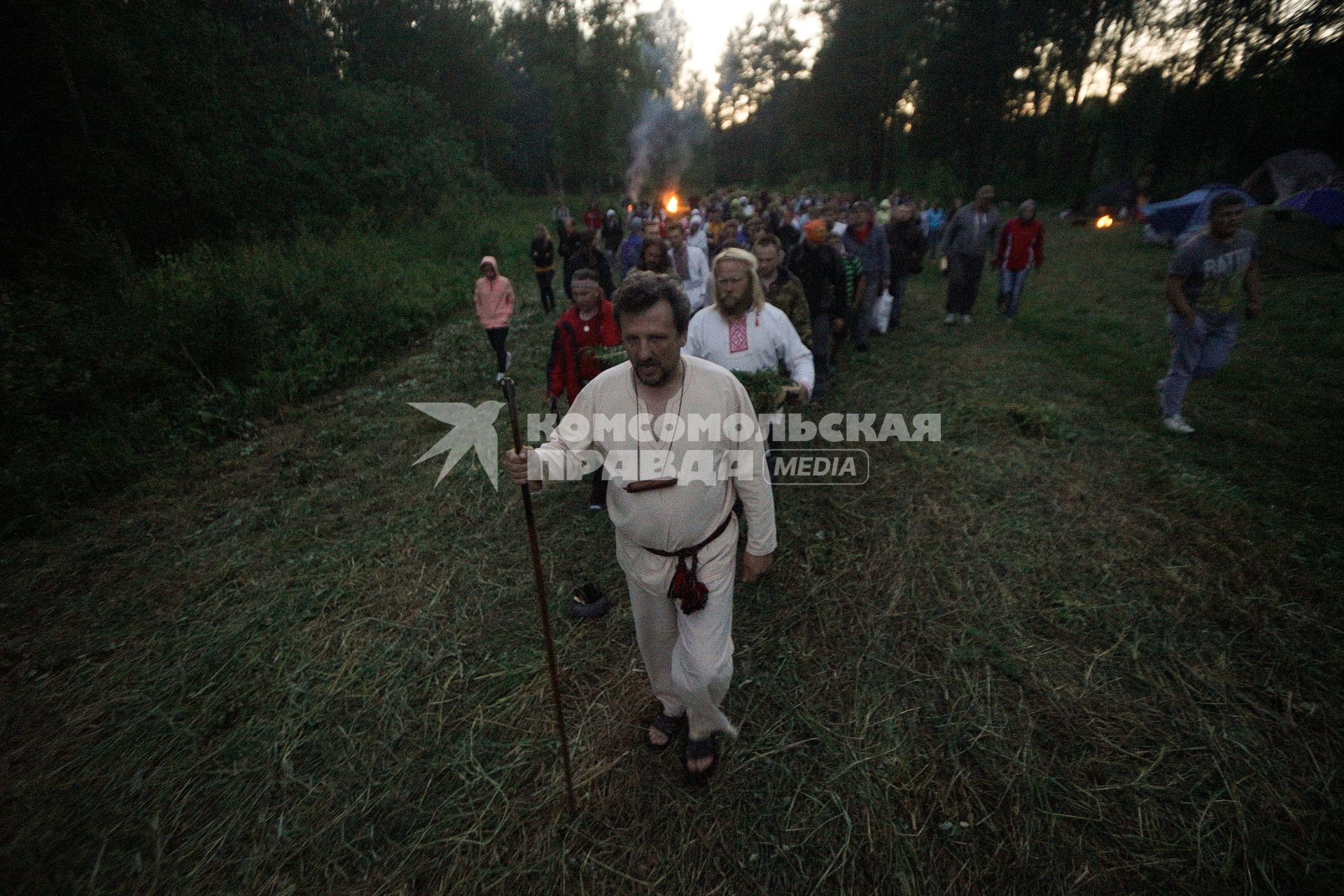 Участники празднования дня Ивана Купала после обряда очищения огнем идут к реке спускать венки