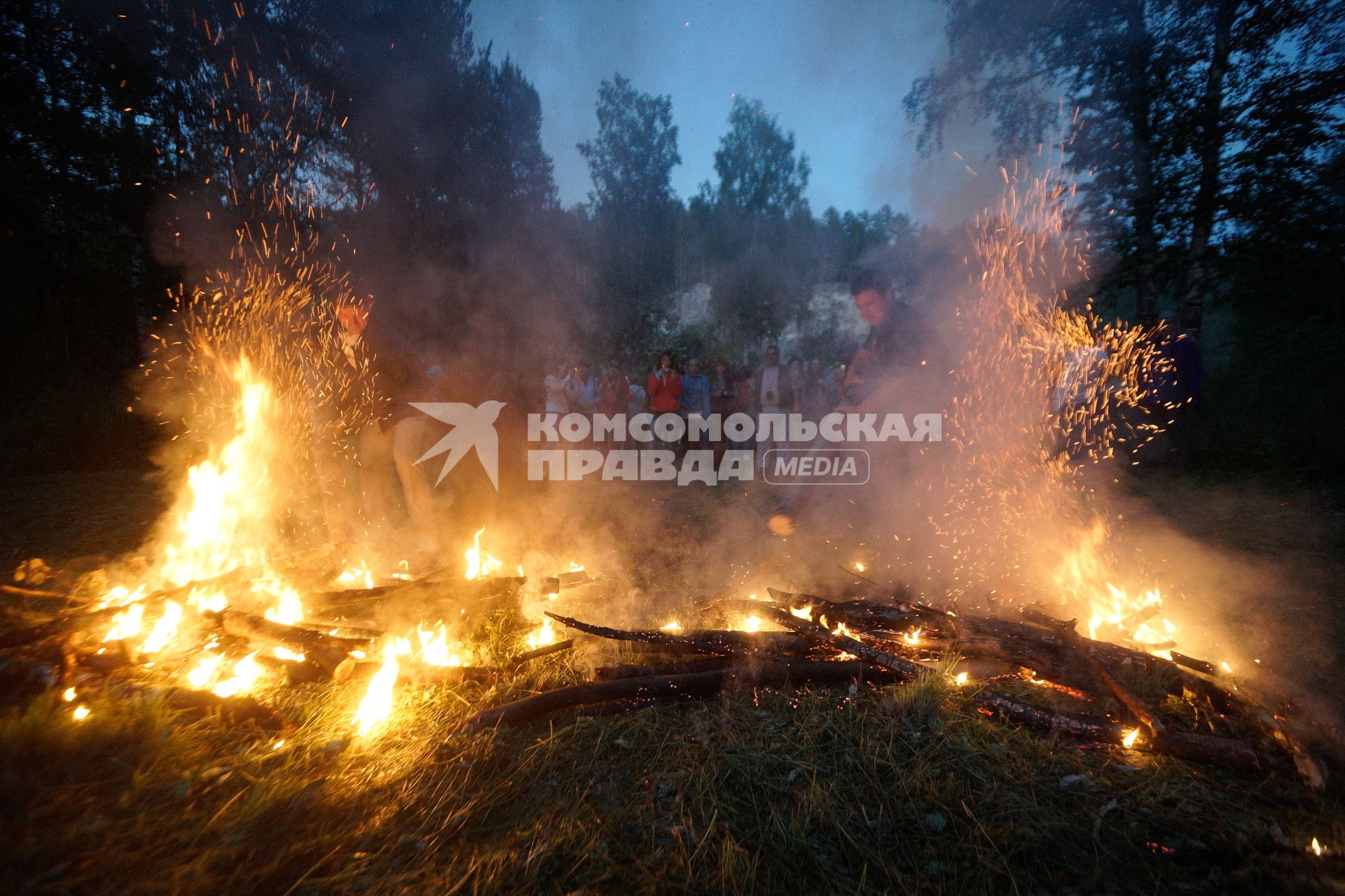 Участники празднования дня Ивана Купала после обряда очищения огнем рушат два больших костра (закрывая ворота)