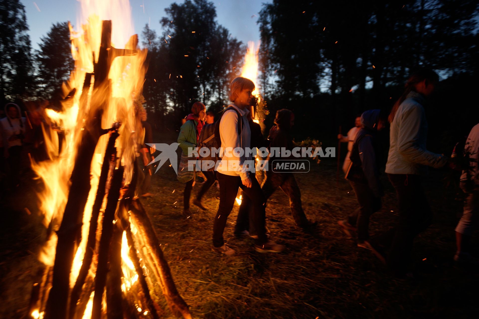 Участники празднования дня Ивана Купала во время обряда очищения огнем проходят между двух больших костров