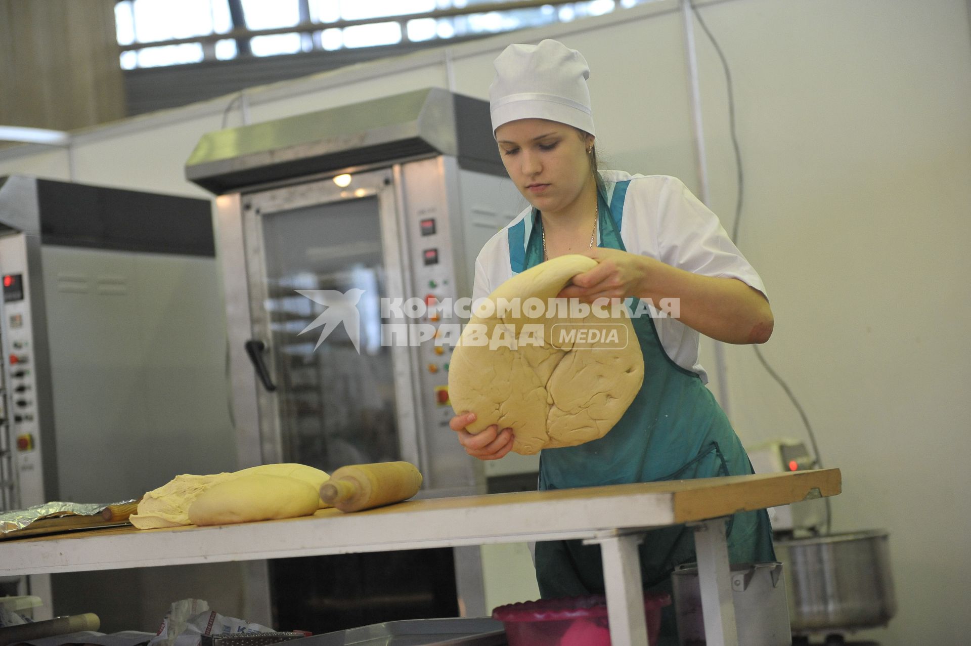 ВВЦ. Ежегодный форум для пекарей и кондитеров России `Праздник хлеба 2014`. На снимке: девушка заготавливает тесто.