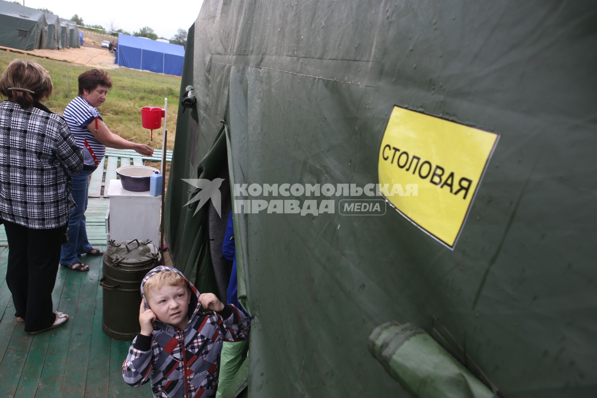 Люди около столовой в палаточном лагере для беженцев из Украины. Донецк, Ростовская область.