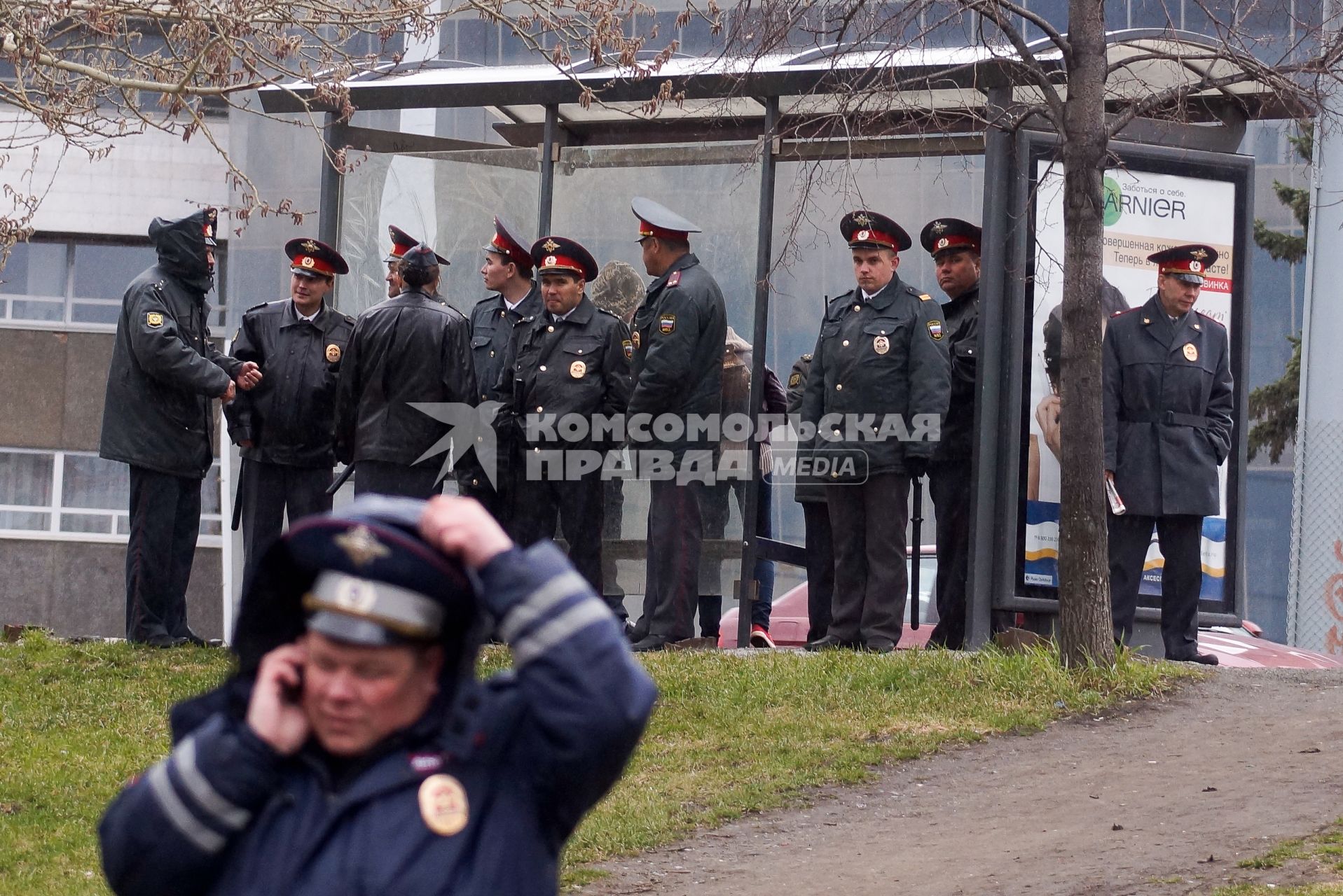 Полицейские стоят у остановки укрываясь от дождя после первомайского шествия в Екатеринбурге