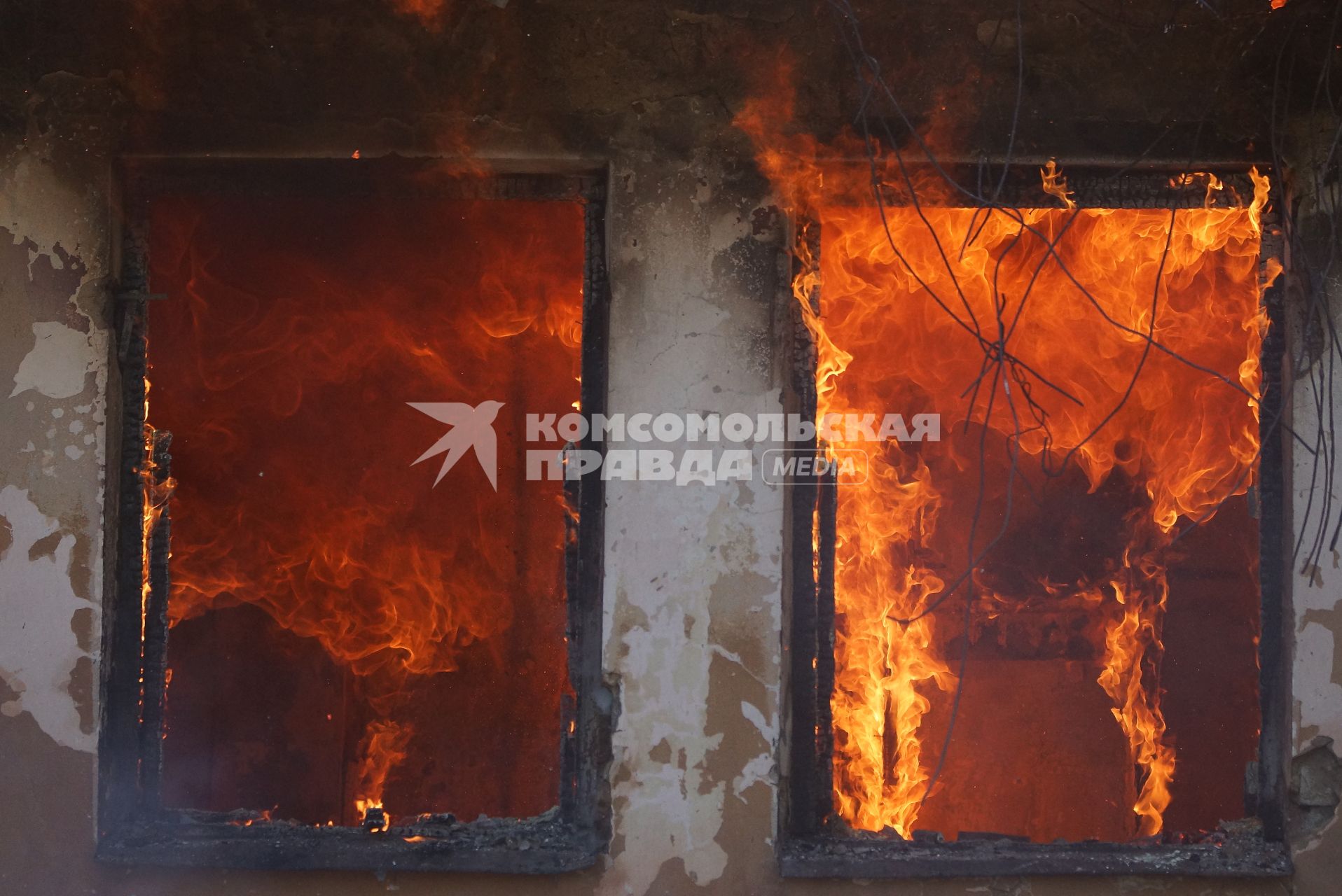 Огонь в окнах дома во время пожара