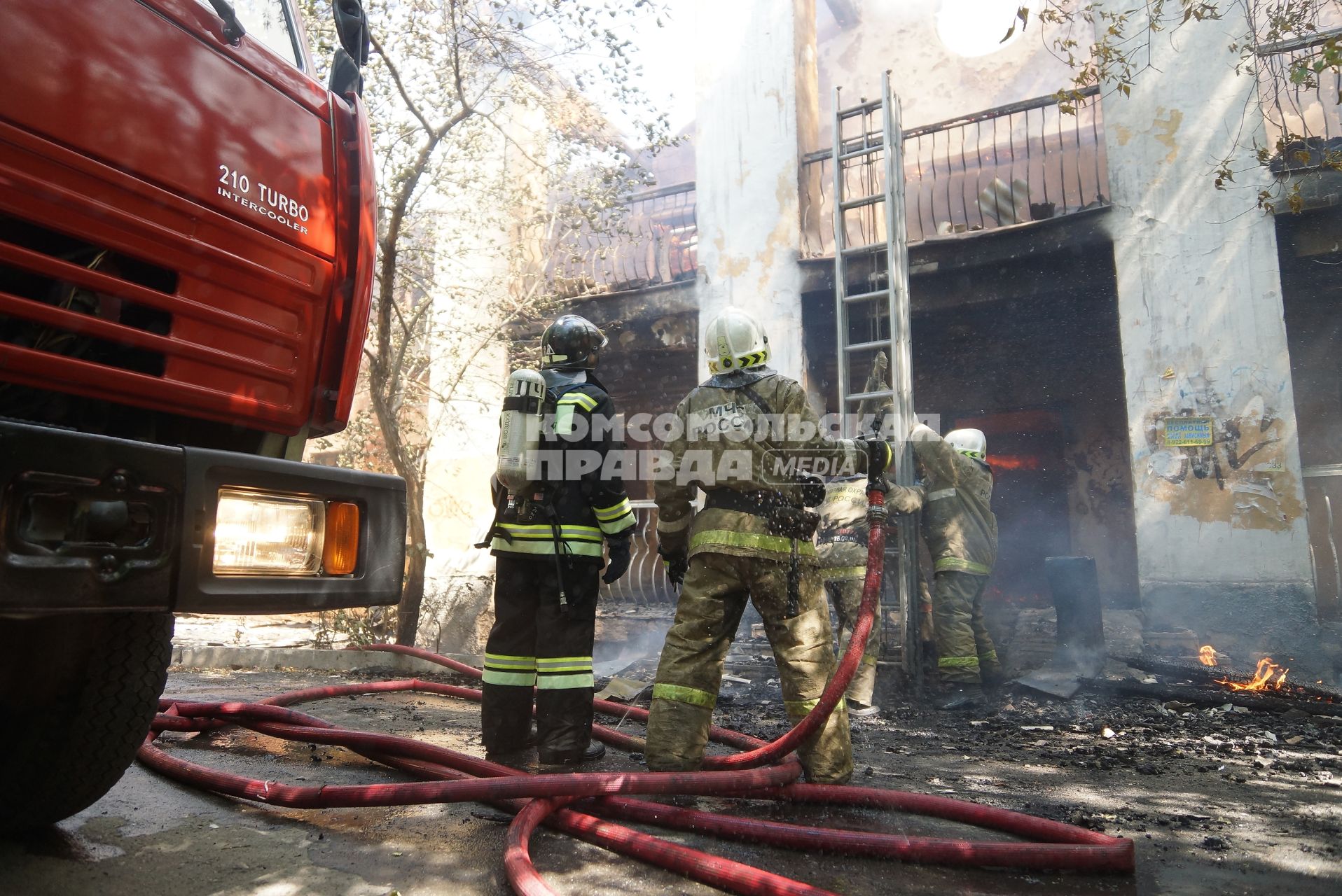 Пожарные ставят раздвижную лестницус балкону для тушения пожара на втором этаже