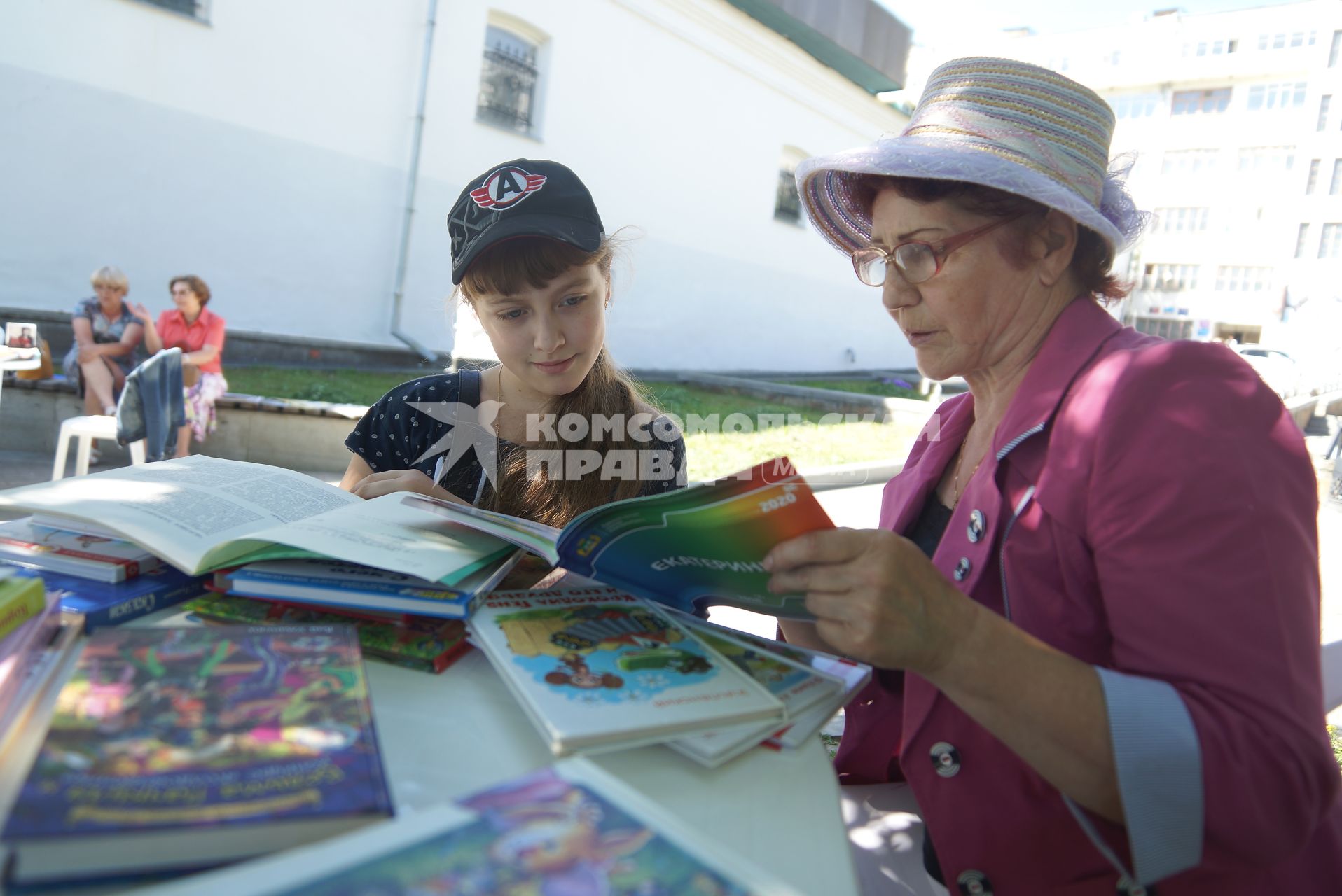 бабушка с внучкой читают книгу в библиотеке под открытым небом  в Екатеринбурге