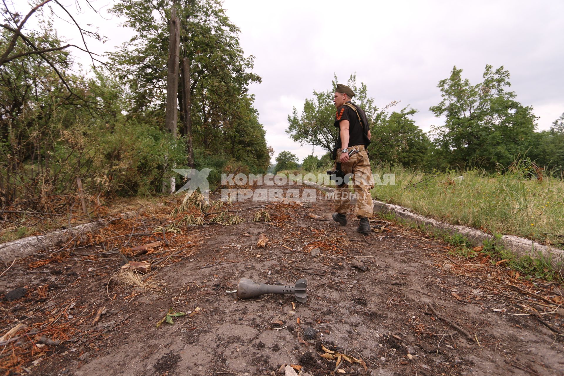 Село Семеновка. Украинская армия обстреляла село запрещенными фосфорными минами. Подобные использовались в Сирии. На снимке: мина, внешне обычная 120-миллиметровая мина, но с кассетной боеголовкой, начиненной фосфорным зажигательным веществом. Справа - ополченец с позывным `Моторола`.