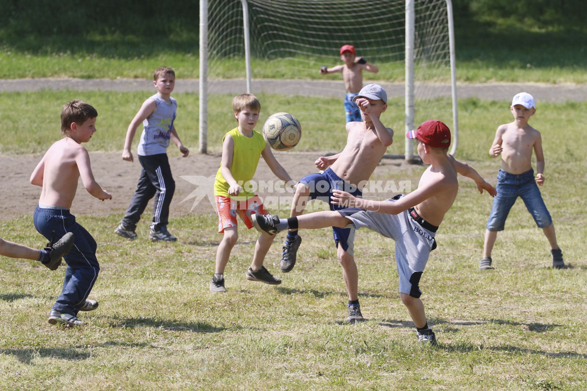 Дети играют в футбол в лагере.