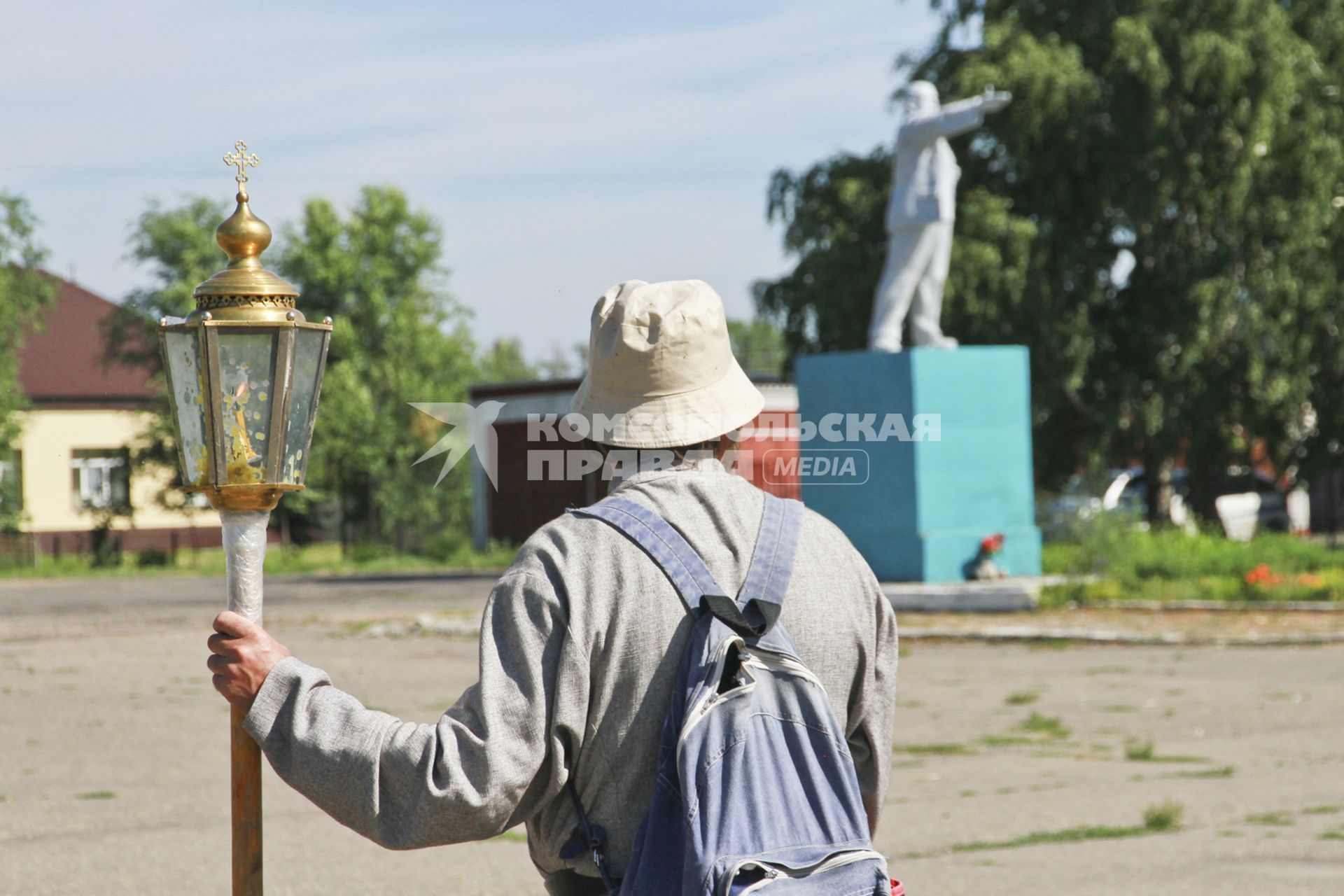 Крестный ход в село Коробейниково к иконе Казанской Божией Матери. Паломник с фонарем - подсвечником и памятник В.И. Ленину.