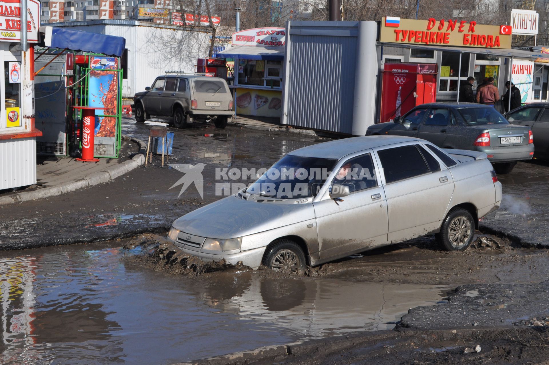 Бездорожье в Омске. Автомобиль проезжает по огромной луже.