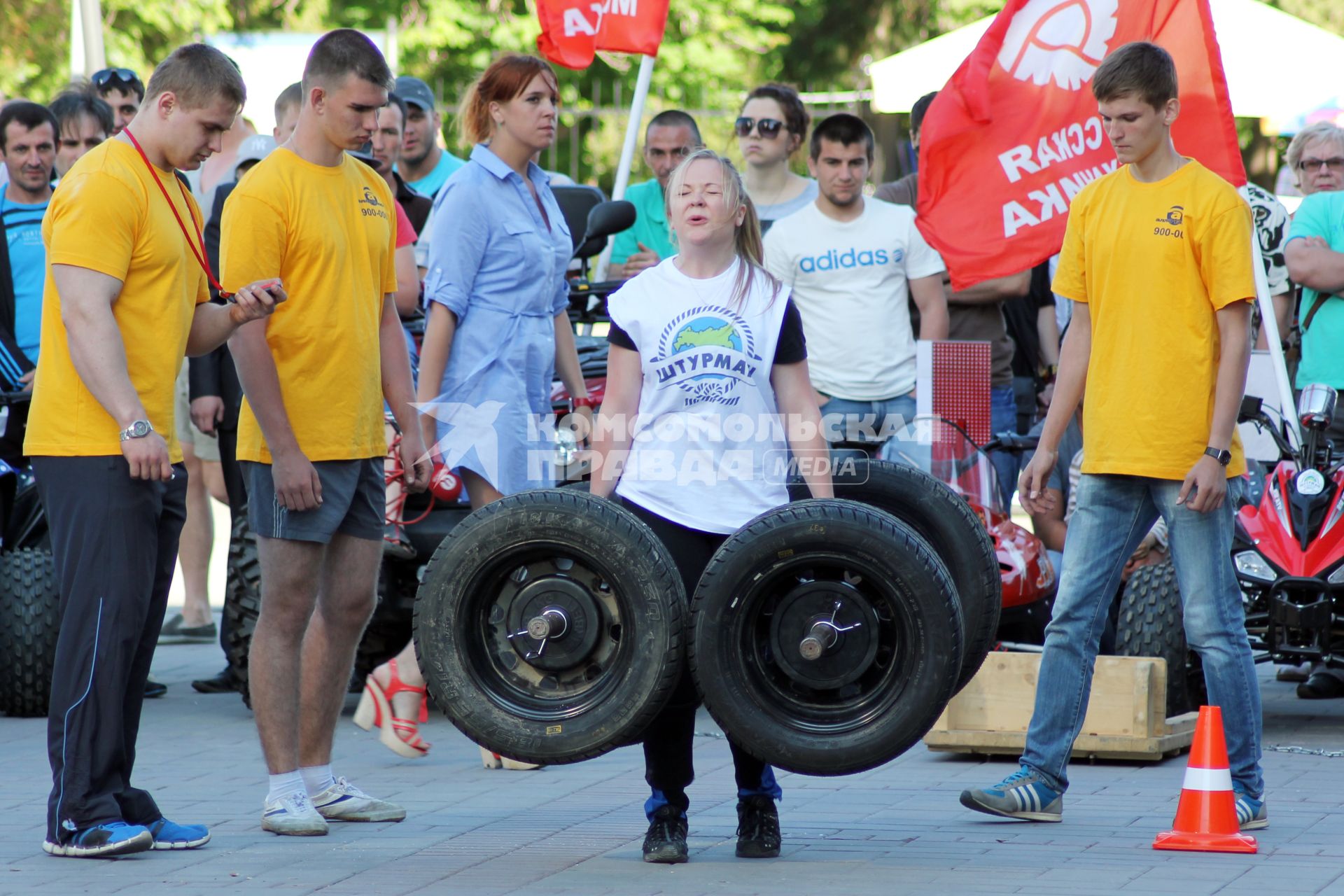 Турнир по силовому экстриму под названием `Strongwoman` в Саратове. Женщина поднимает гантели из автомобильных колес.