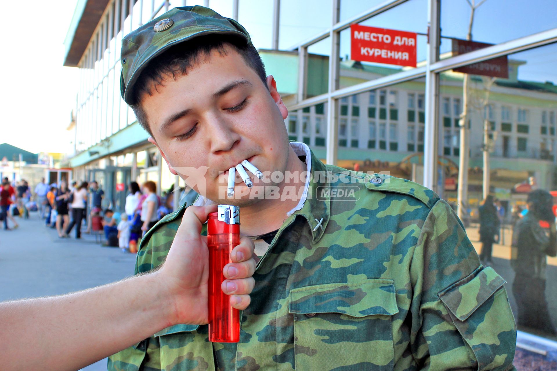 Солдат прикуривает три сигареты.