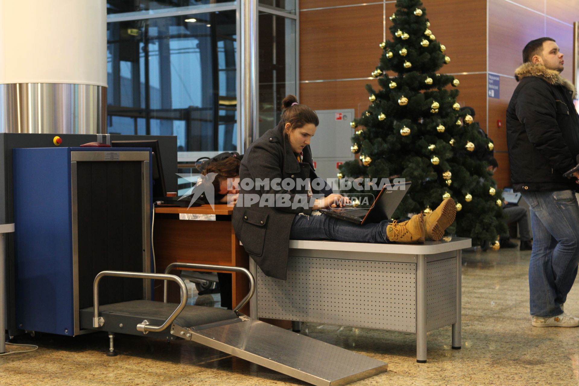Транспортный коллапс в аэропорту  Шереметьево-2. На снимке: пассажирка сидит с ноутбуком на стойке у рентгеновского досмотра.