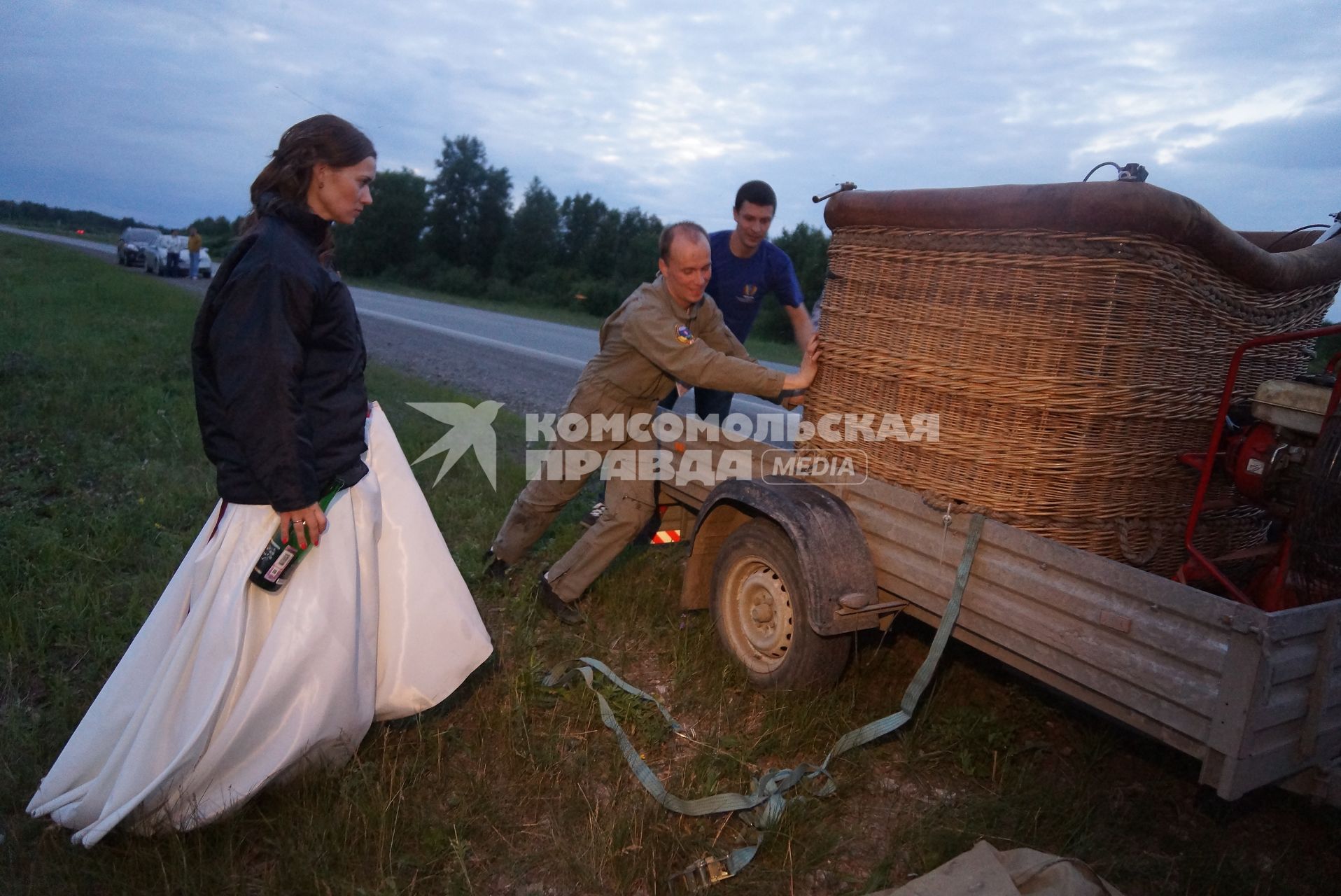 невеста с  шампанским в руке наблюдает за погрузкой корзины аэростата