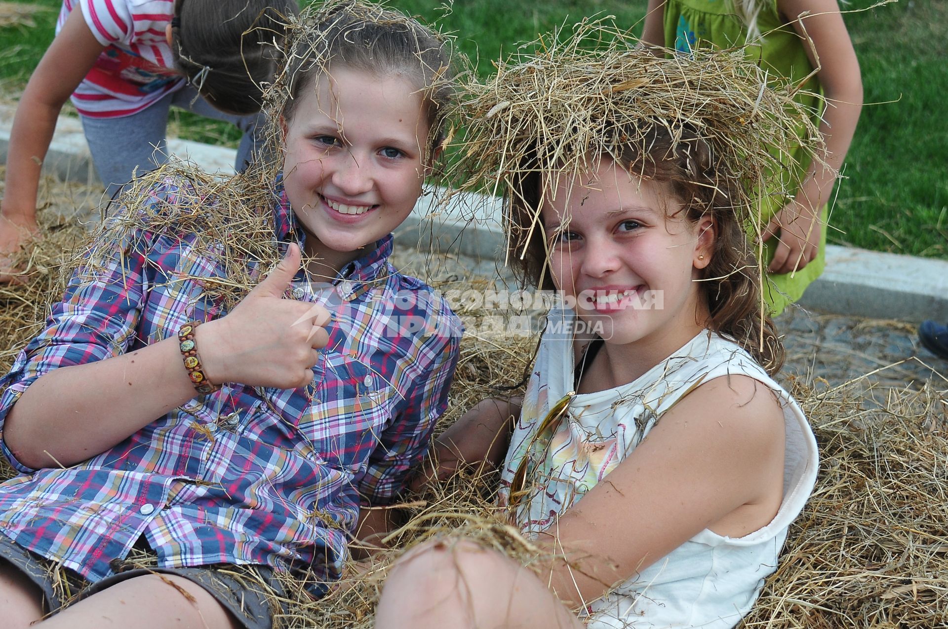 День семьи, любви и верности в саду Баумана. На снимке: девочки сидят в стоге сена.