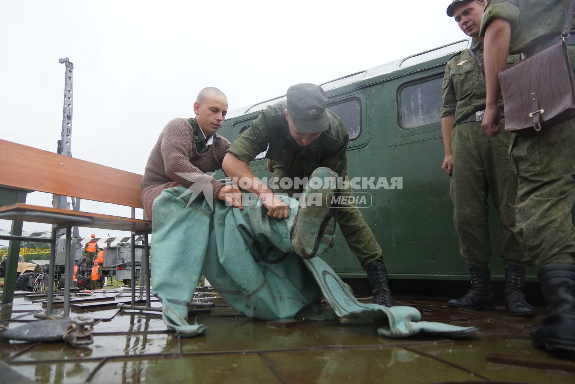 Солдат железнодорожных войск одевает водолазный костюм