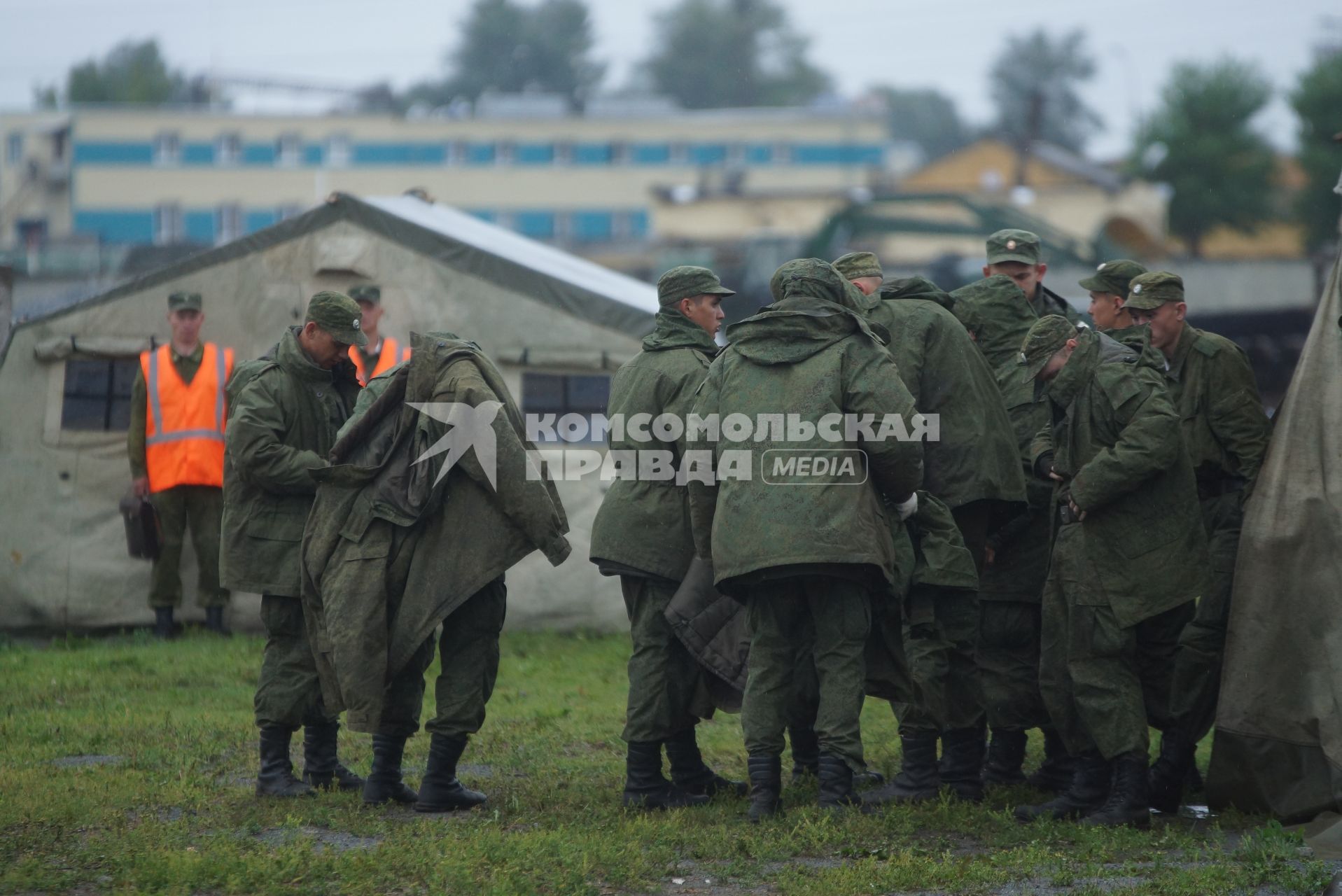 Солдат у палаточного лагеря одеваются в теплую одежду