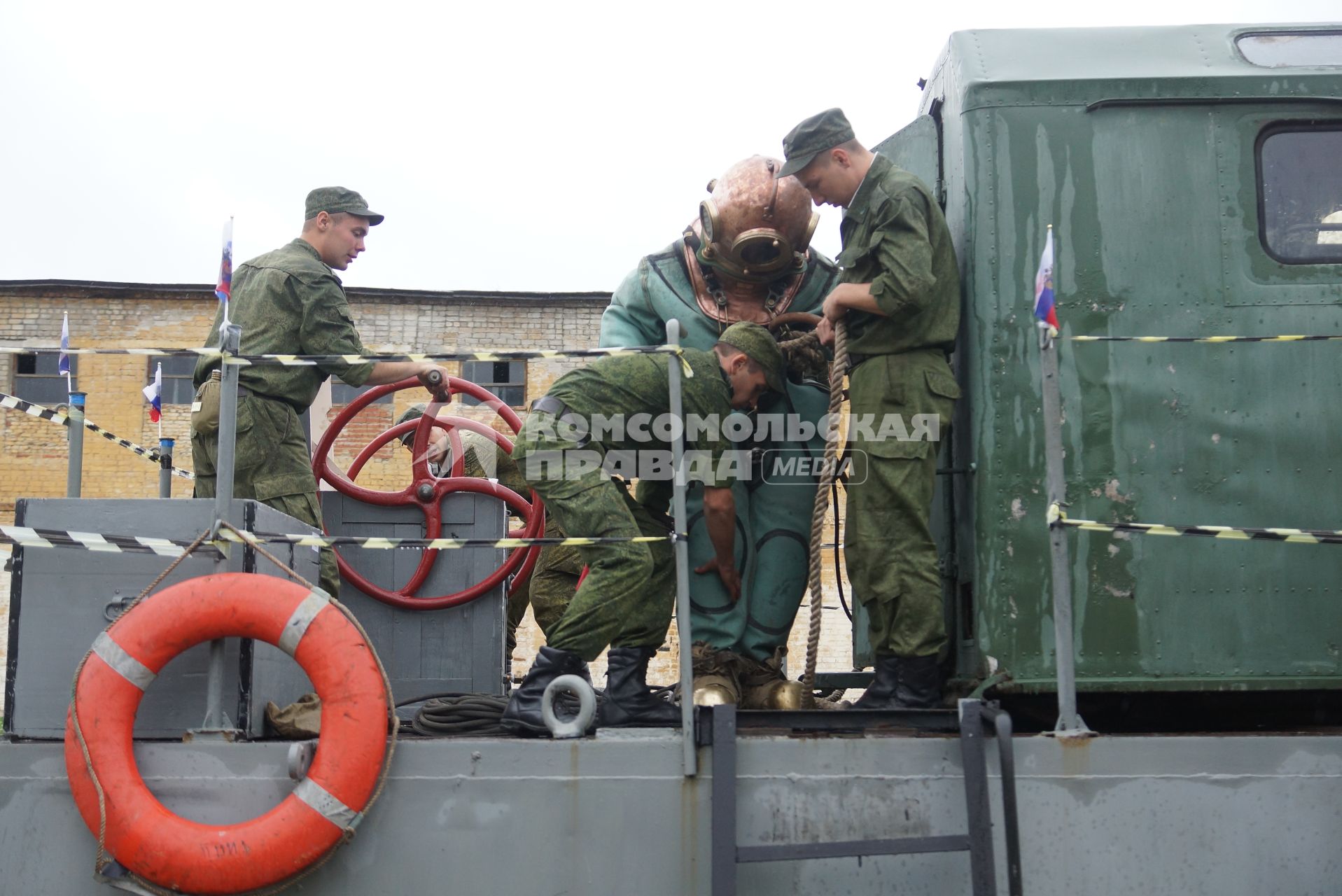 Солдат железнодорожных войск в водолазном костюме готовится к учебному погружению под воду