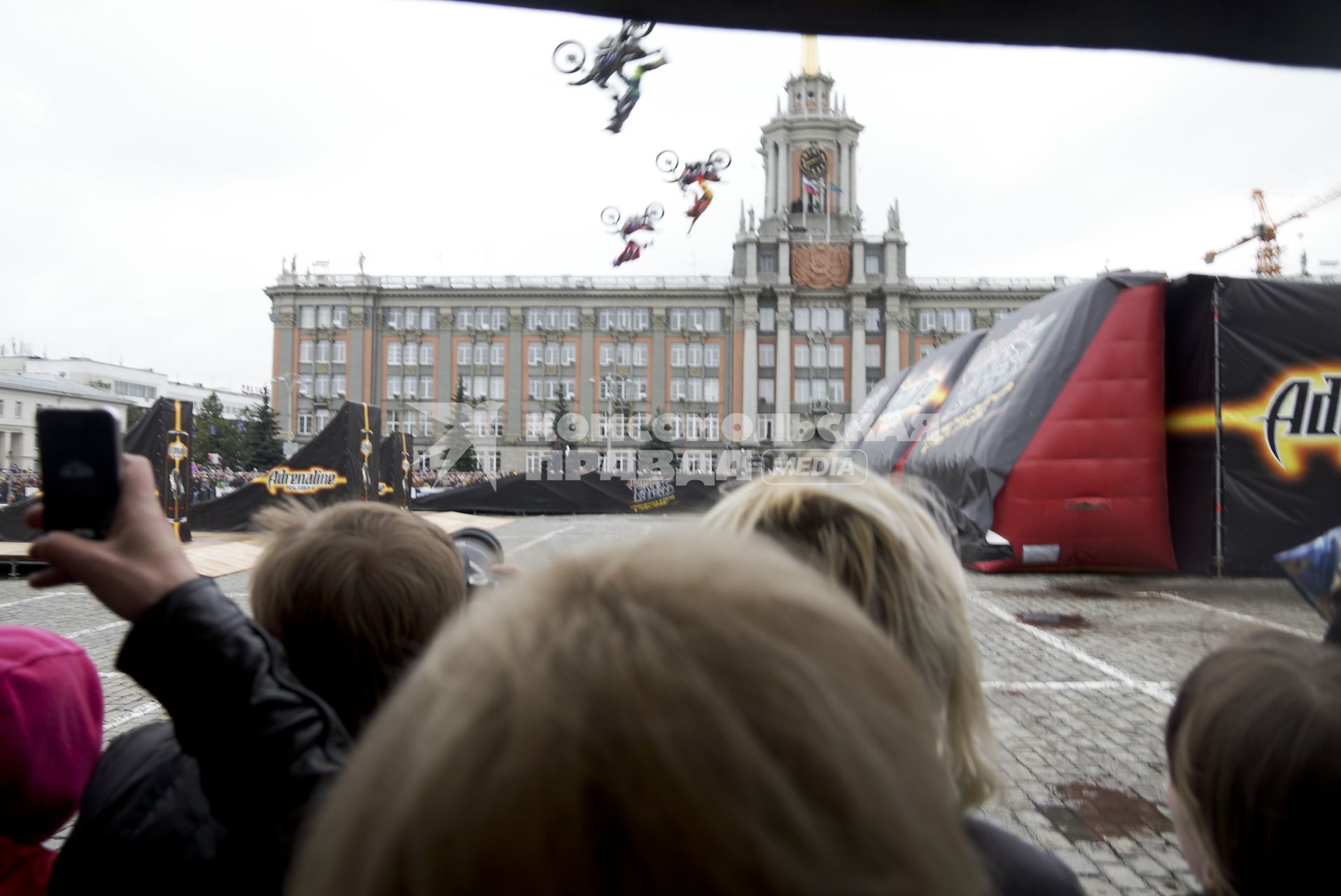 срители смотрят как мотоциклист-экстримал выполняет трюк в воздухе во время мотошоу в Екатеринбурге