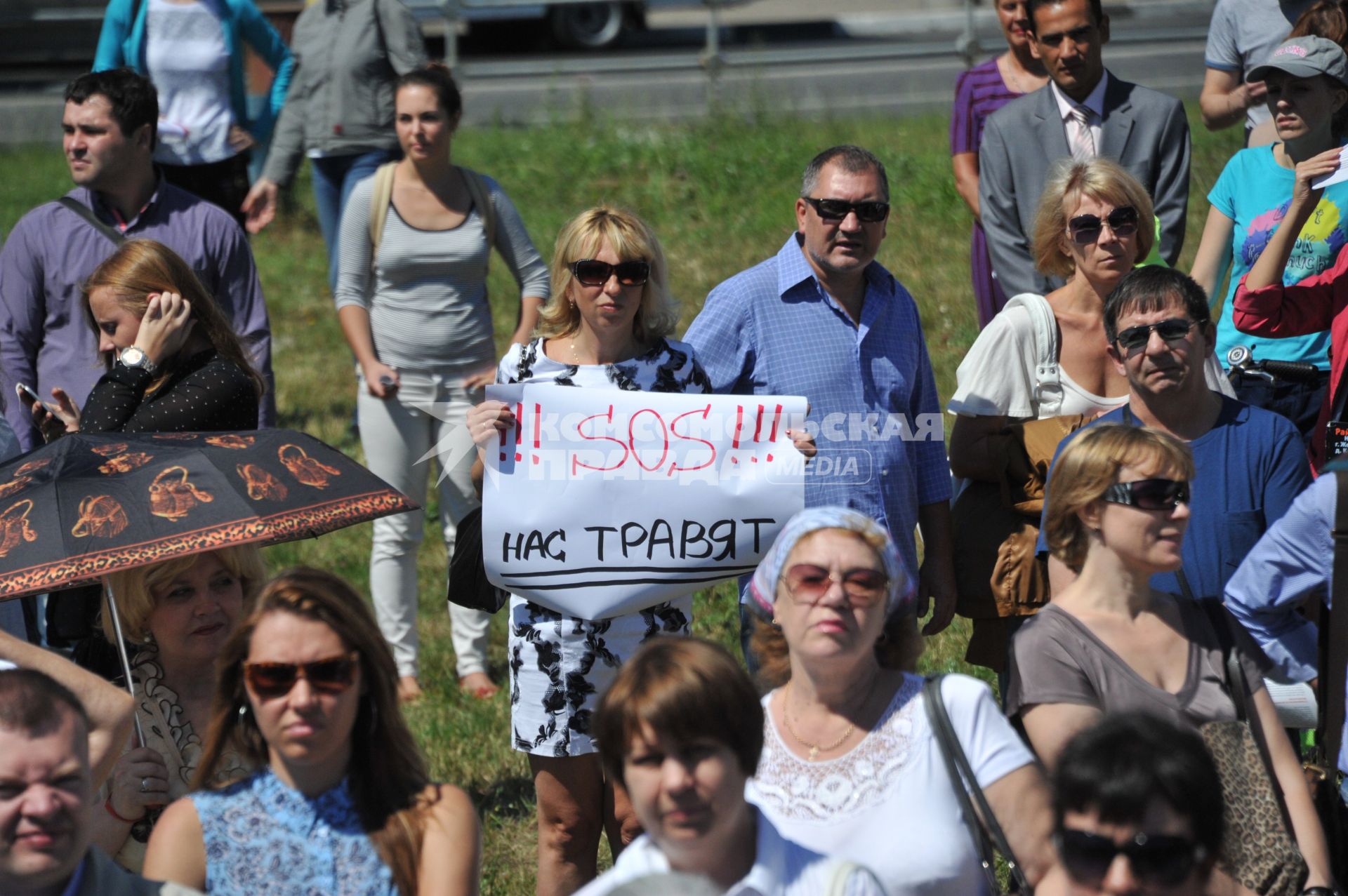 Митинг жителей Кожухово за вывод завода `Эколог` и отказ от  строительства промзоны Руднево. На снимке: женщина держит плакат `SOS!!! Нас травят`.