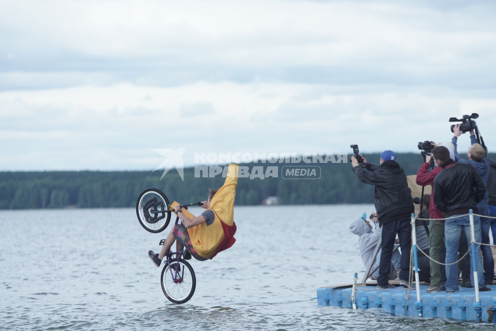 Прыжки на велосипедах в воду Bicycle live fest, парень в костюме банана прыгает на велосипеде с трамплина