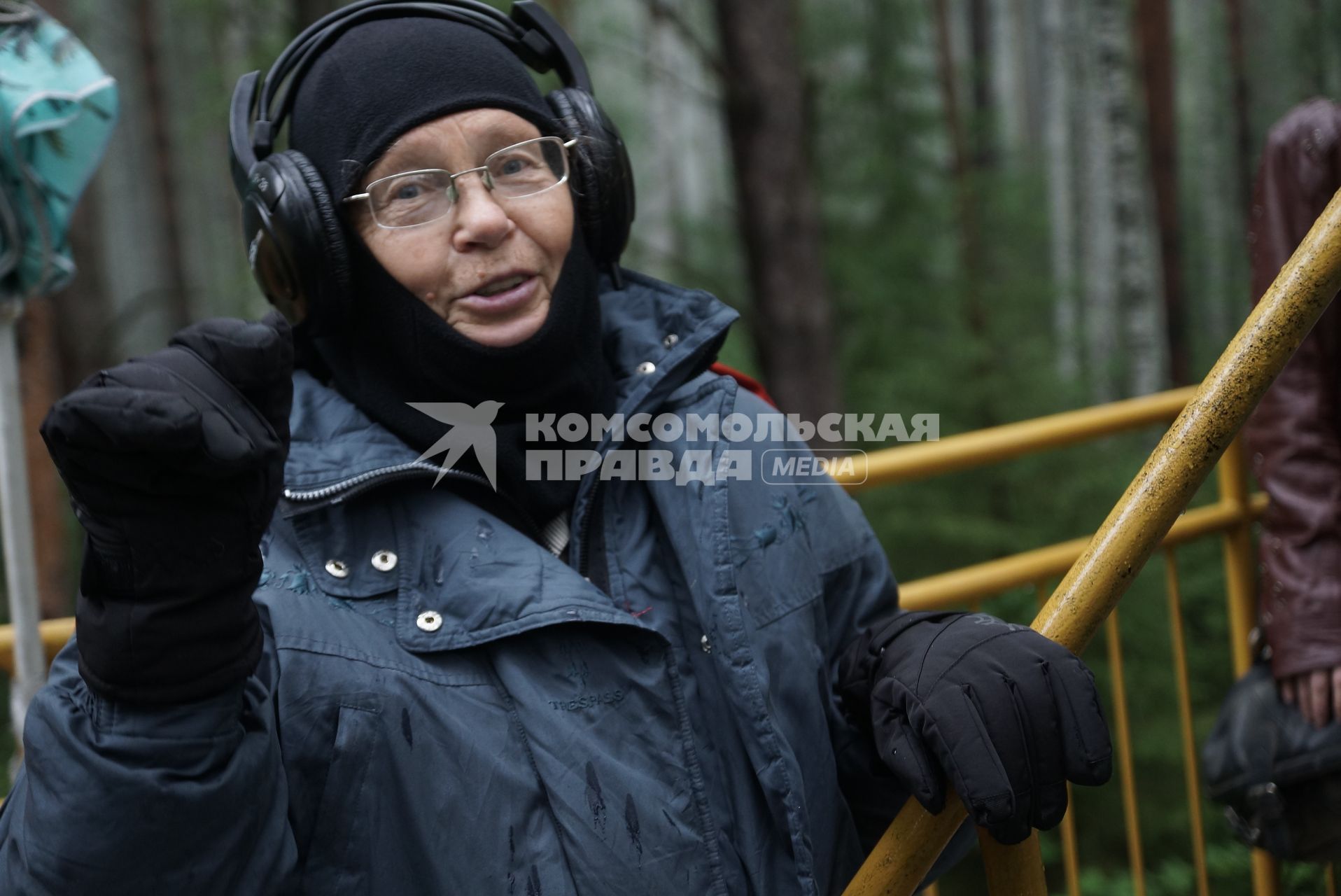 Пенсионерка стоит перед в ходом в аэродинамическую трубу