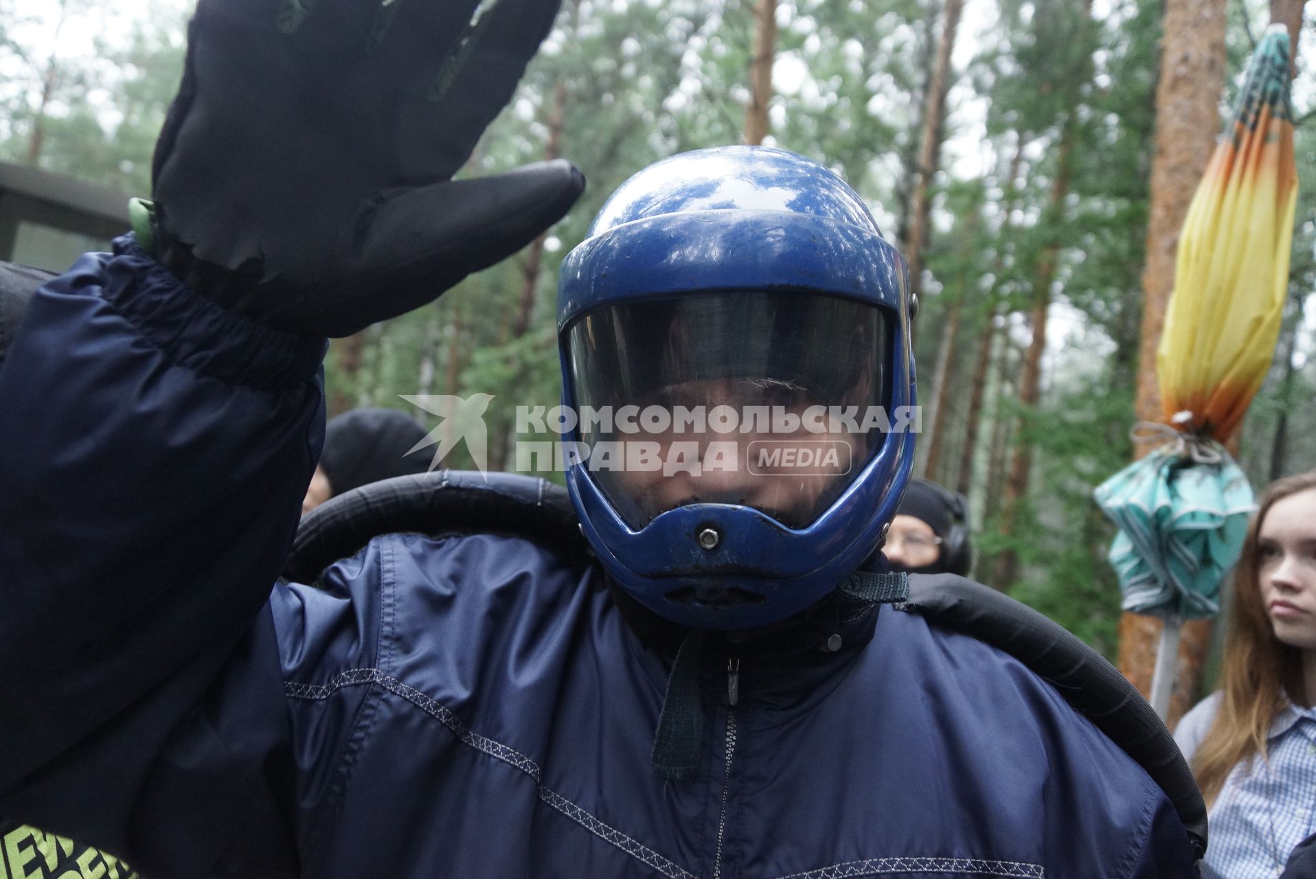 Пенсионер машет рукой перед полетом в аэродинамической трубе под руководством инструктора