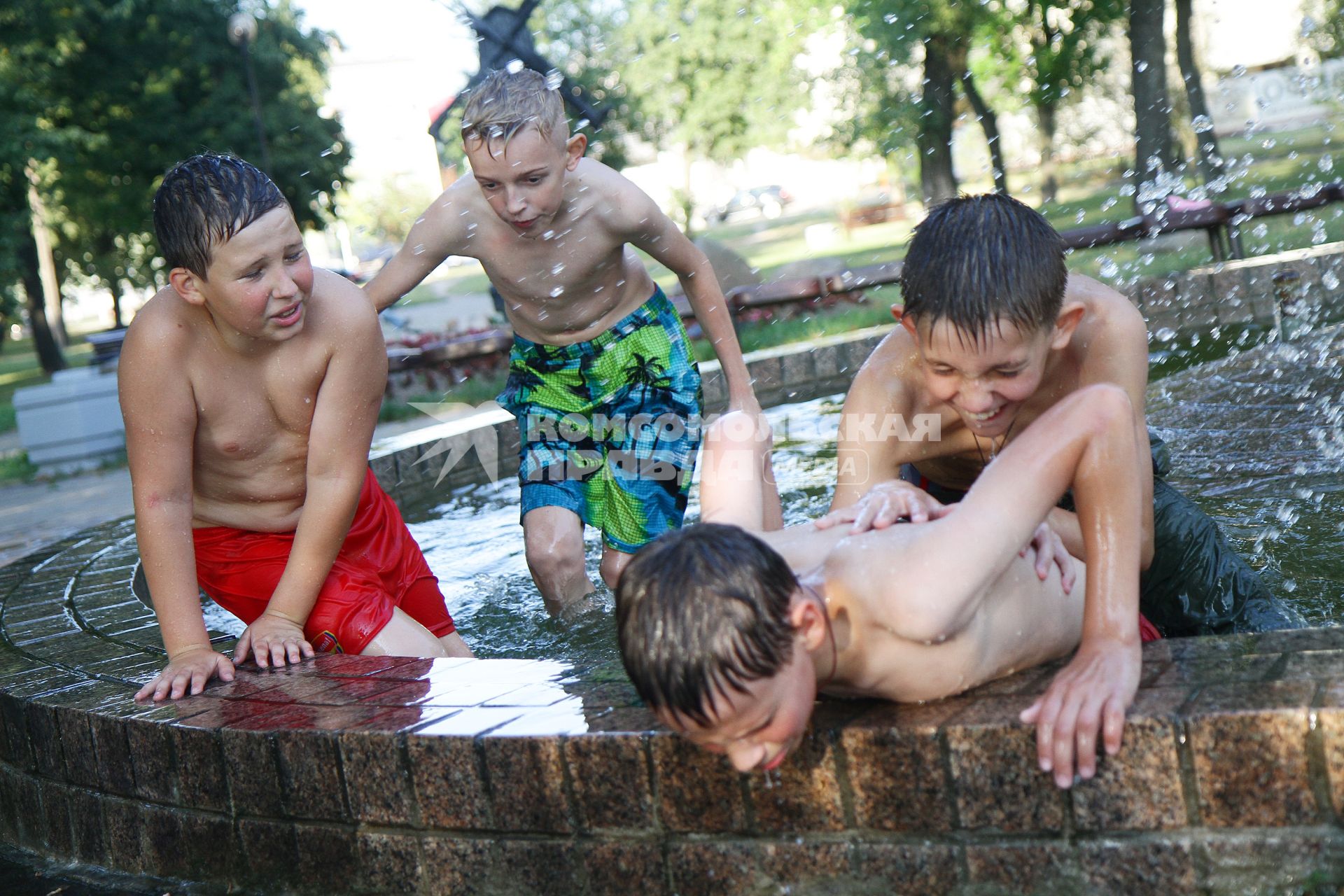 Дети играют в городском фонтане