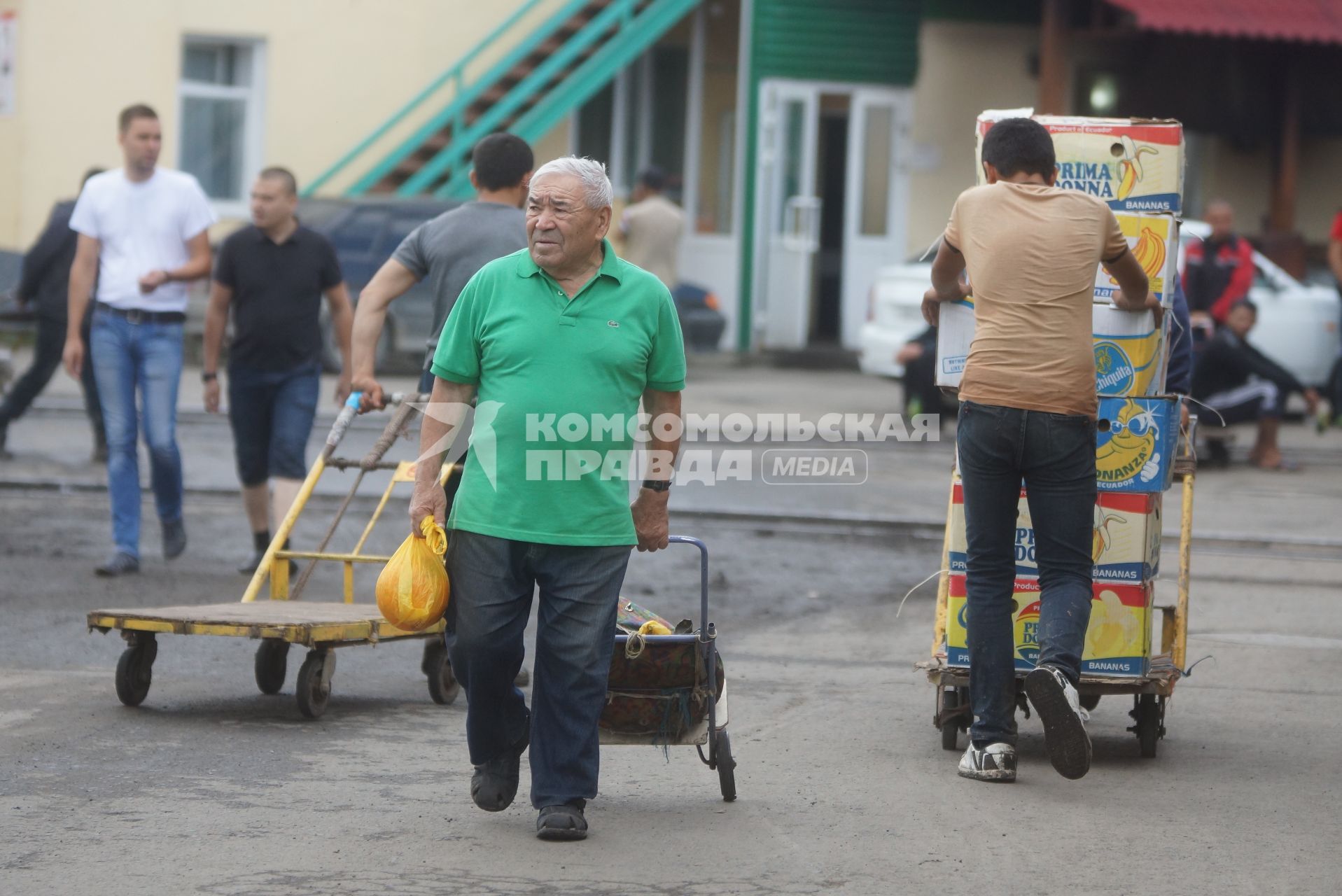 пенсионер на 4-й овощебазы в Екатеринбурге идет с продуктовой тележкой