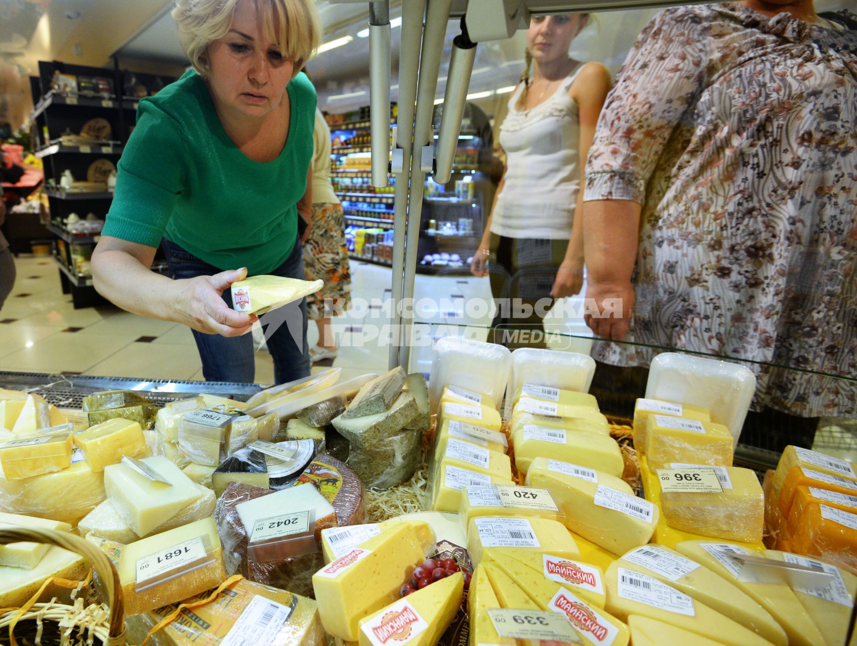 Магазин `Соседушка` в Оренбурге. На снимке: женщина выбирает сыр на витрине.