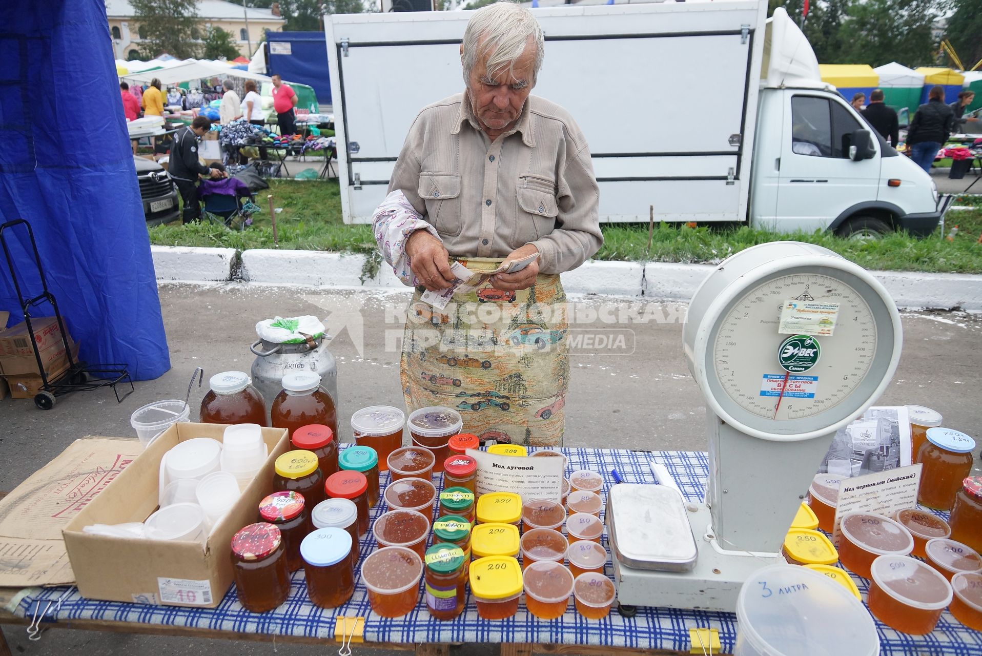мужчина считает деньги после продажи меда на Ирбитской ярмарке