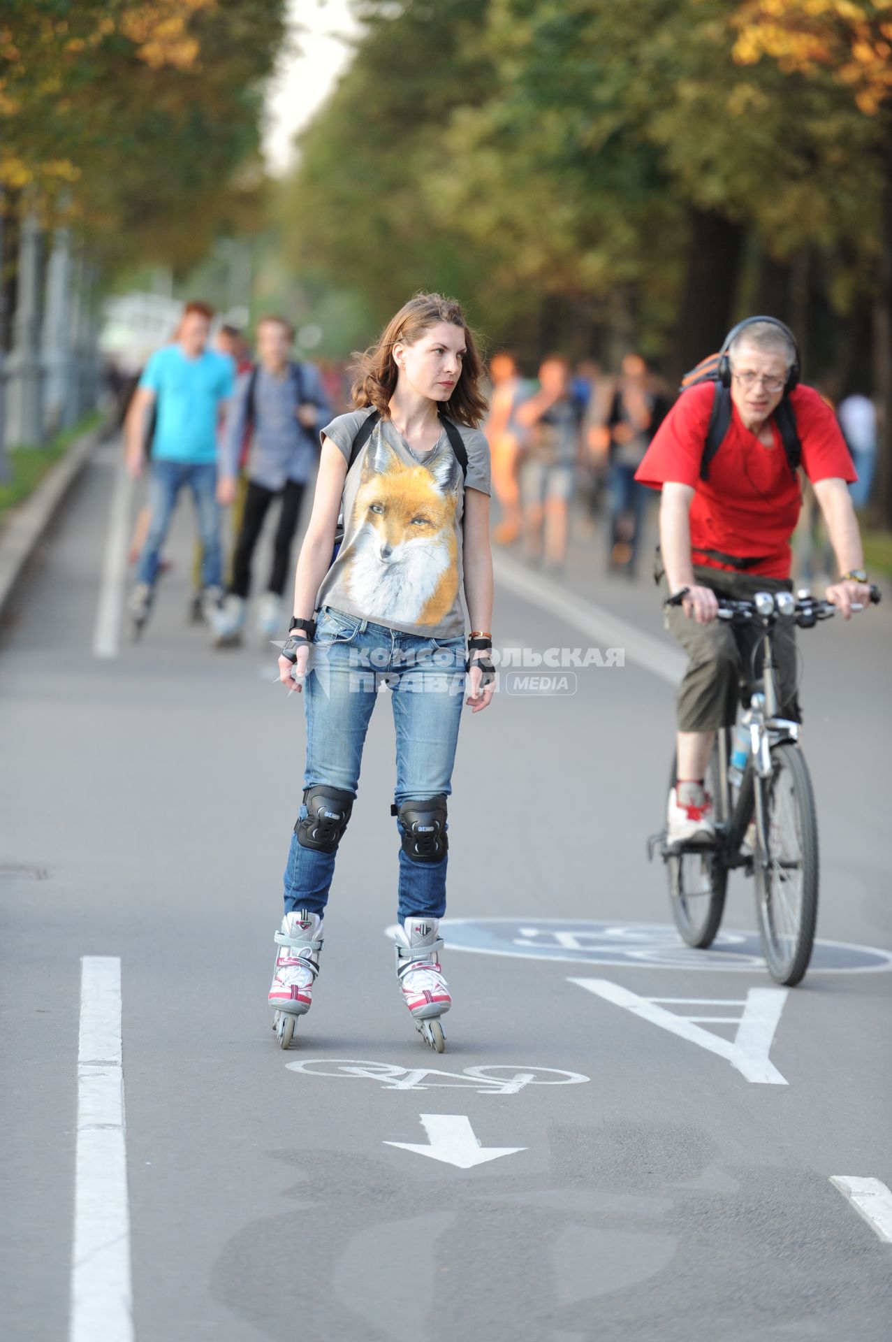 Парк Горького. На снимке: девушка на роликах и мужчина на велосипеде.