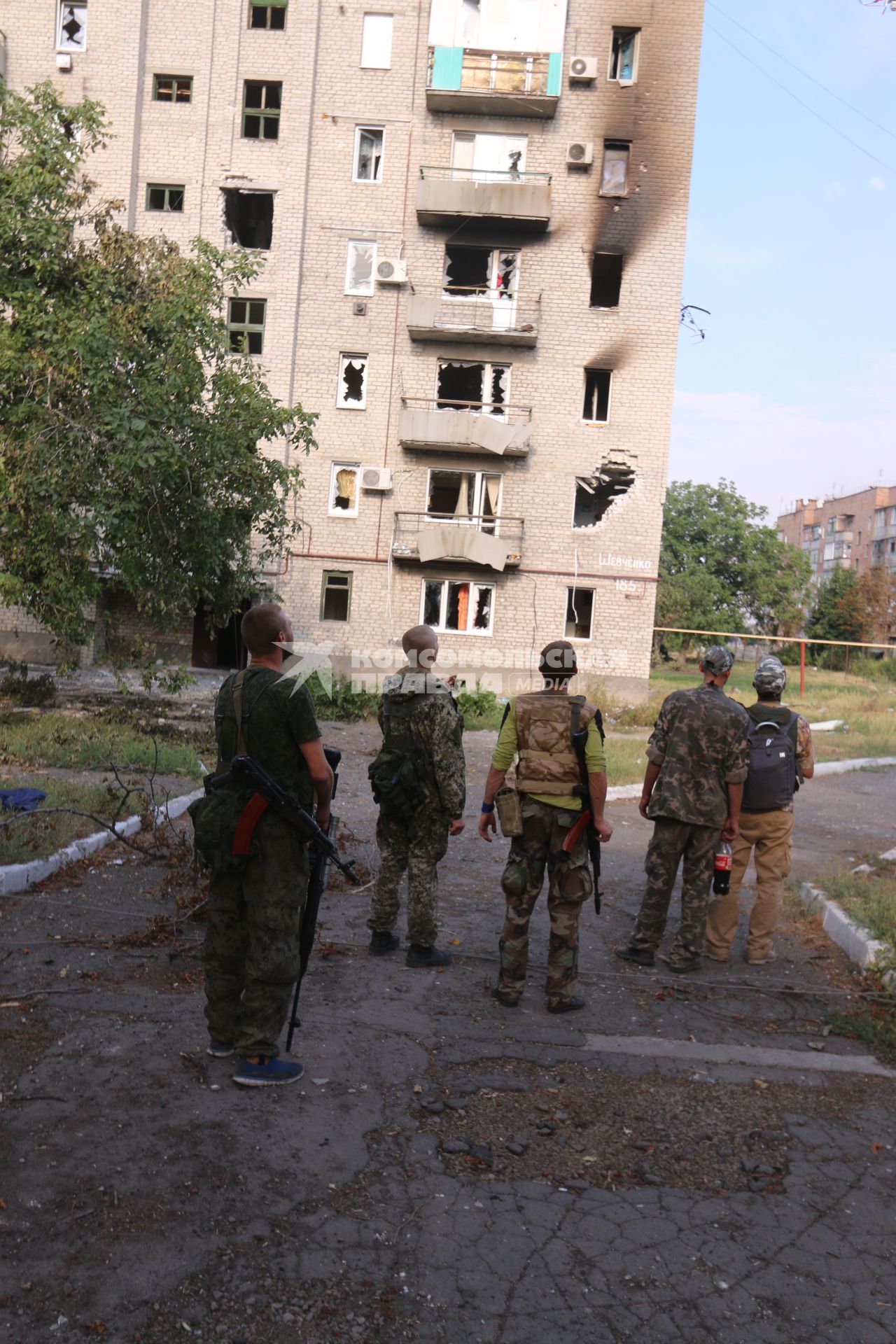 Иловайск. На снимке бойцы ДНР смотрят на многоэтажный жилой дом, подвергшийся артиллерийскому обстрелу ВС Украины.