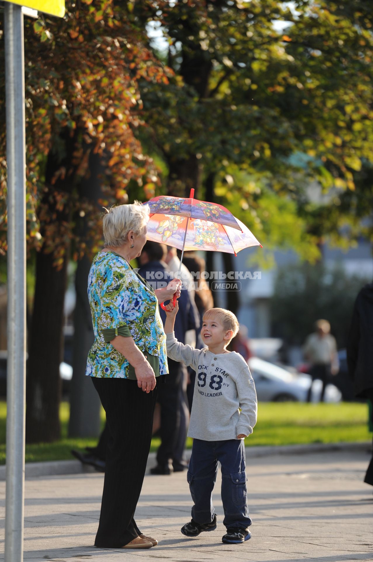 Открытие пешеходных зон на улицах Покровка и Маросейка. На снимке: женщина и мальчик держат зонт.