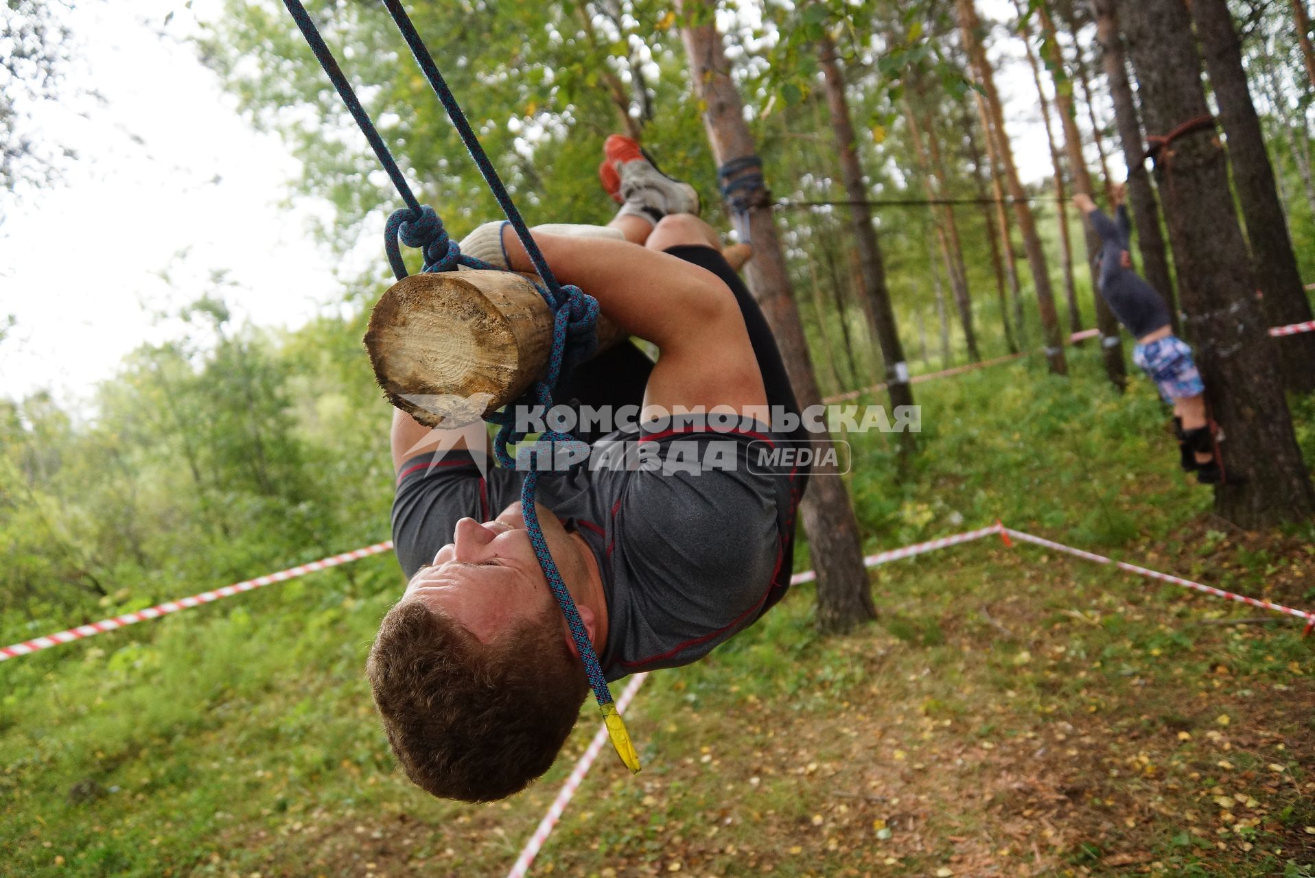 Участник грязных гонок Ural Dirty Race 2014 под Екатеринбургом ползет по подвешаному бревну