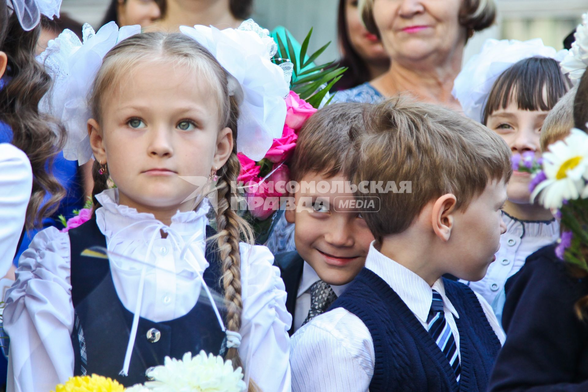 Мальчик выглядывает из-за плеч одноклассников на линейке школы 88 Воронежа