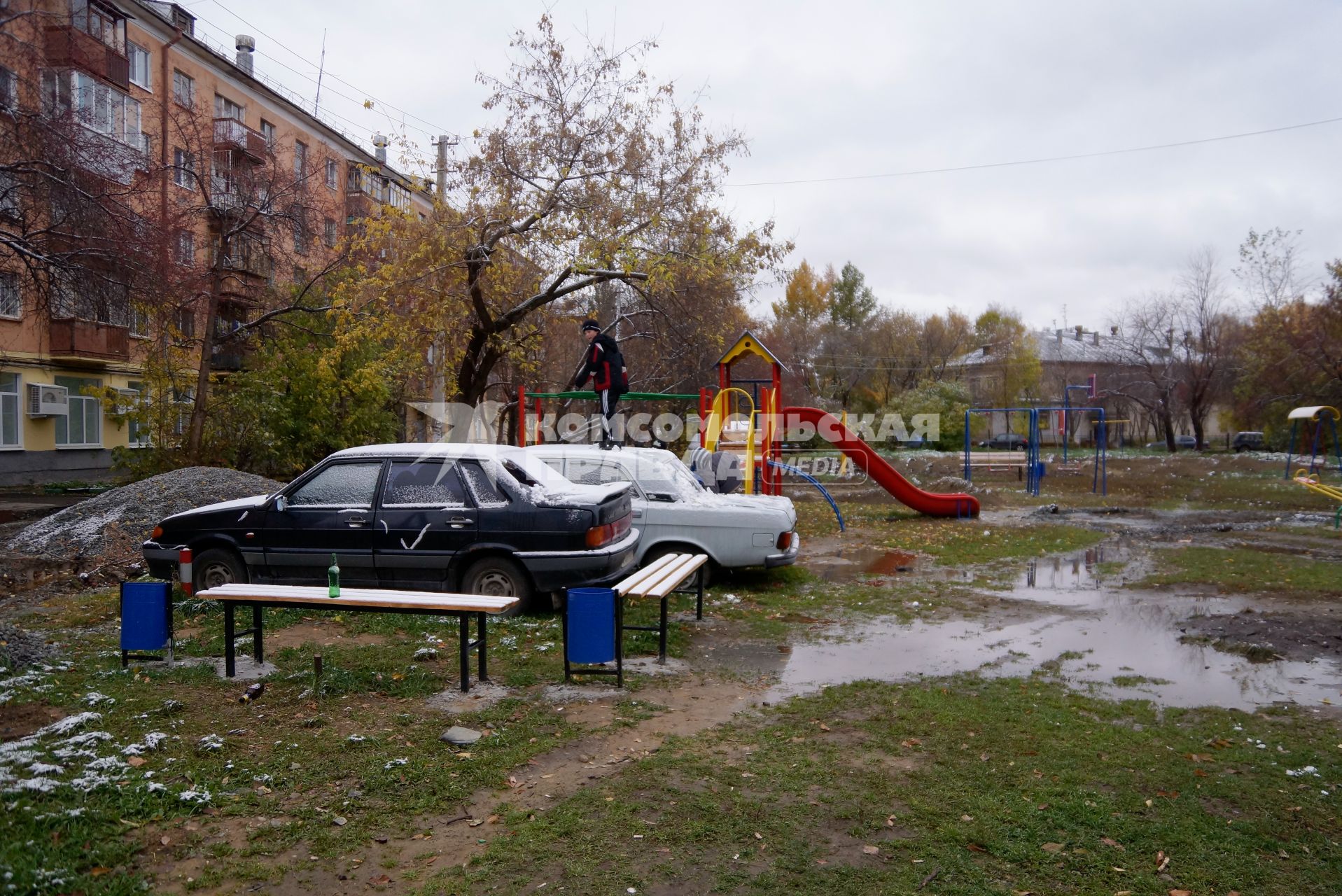 мальчики играют у старой машины Волга, на детской площадке во дворе жилого дома