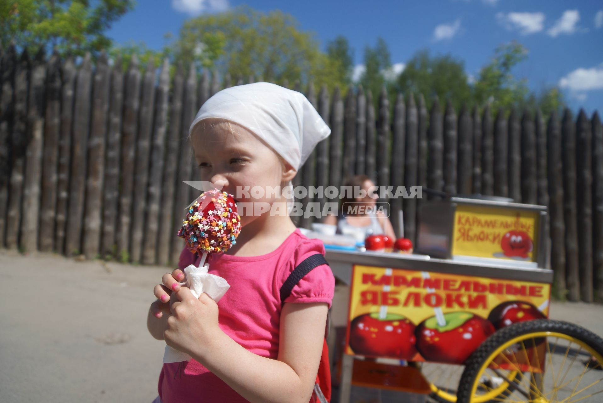 девочка ест яблоко в карамели