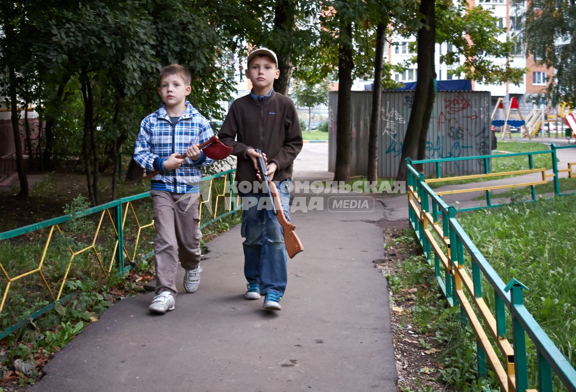 Дети с игрушечным оружием играют в войнушку.