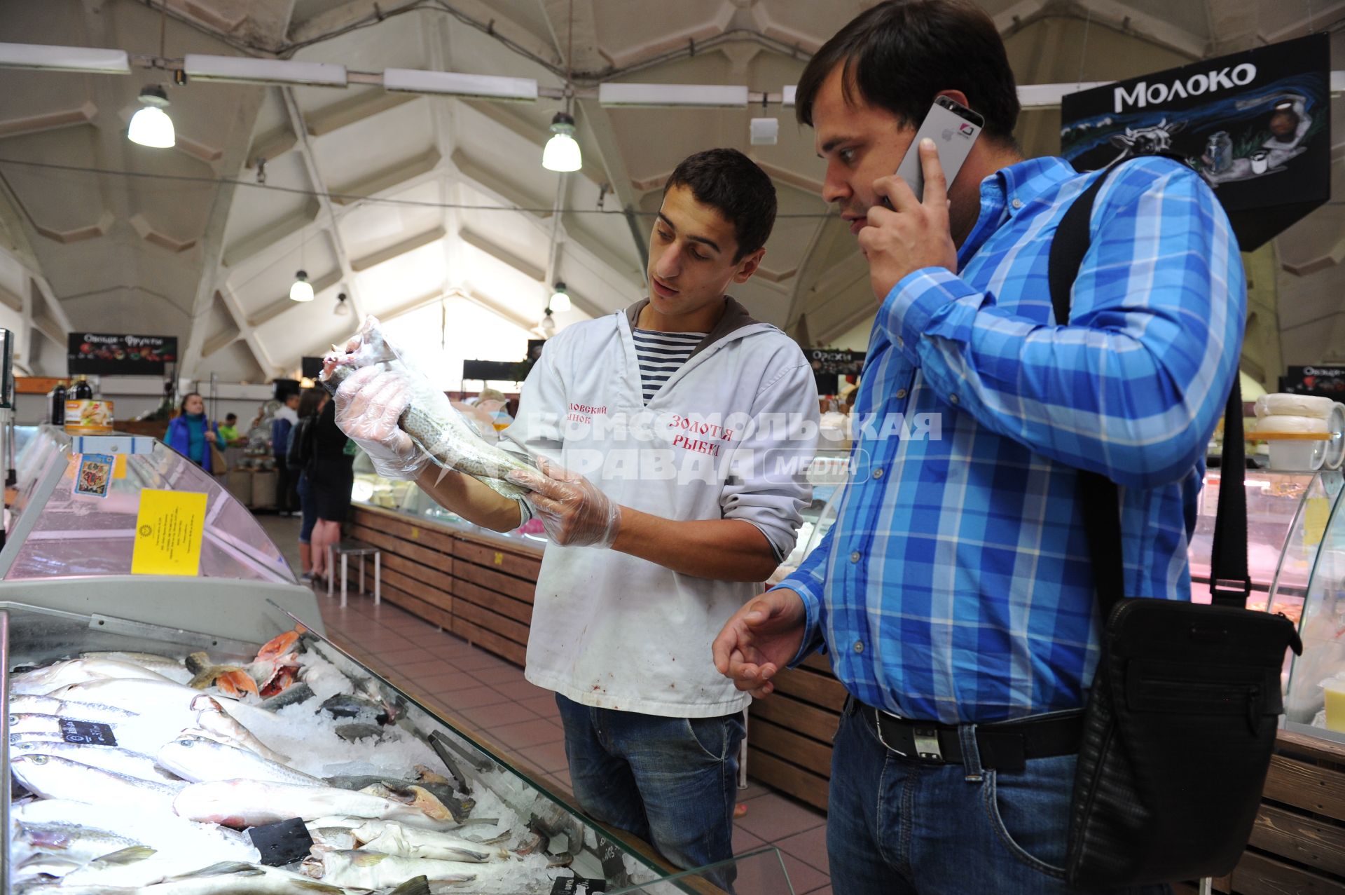 Даниловский рынок. Рыбные ряды. На снимке: продавец рыбного отдела показывает покупателю лосось.