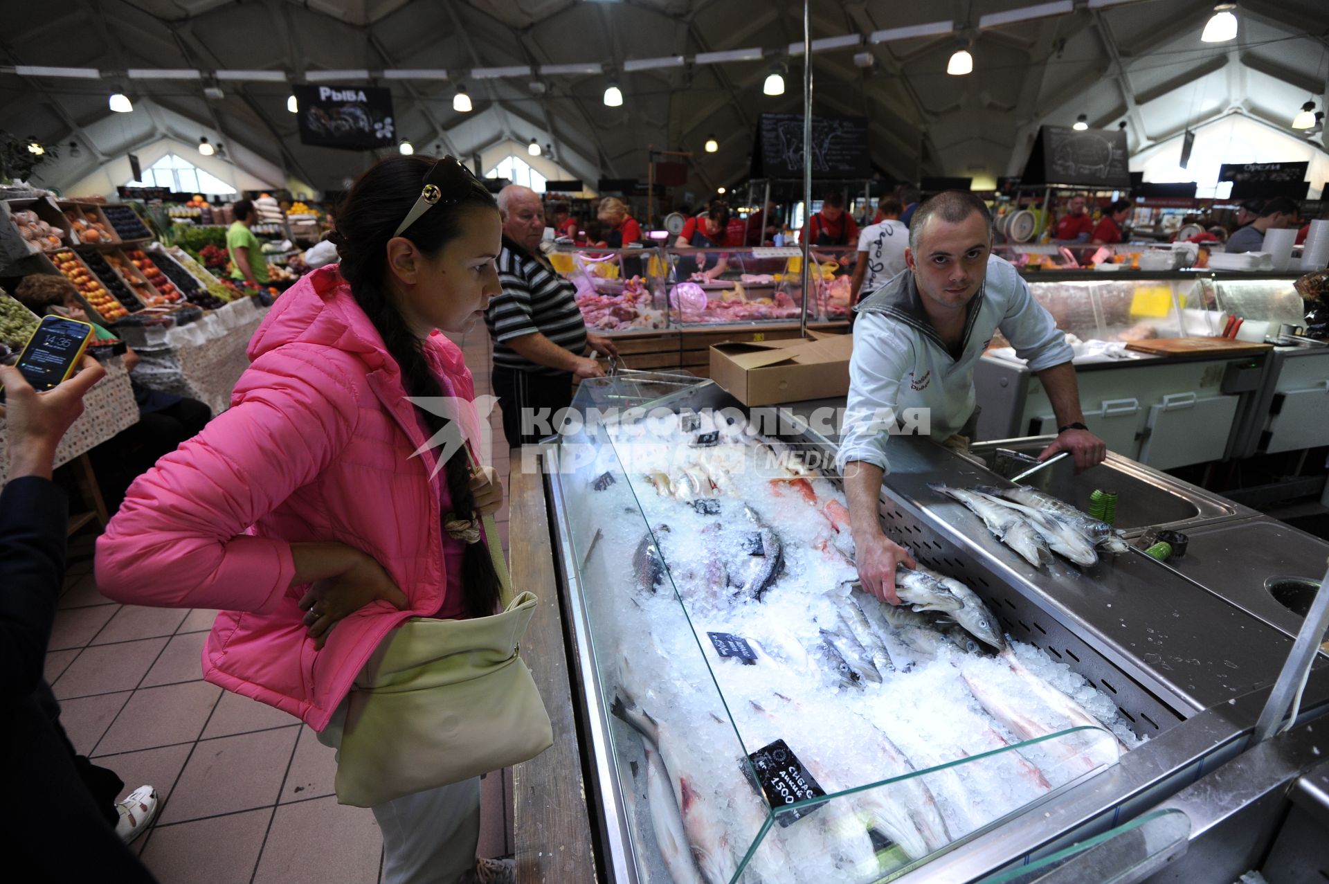 Даниловский рынок. Рыбные ряды. На снимке: продавец рыбного отдела показывает покупательнице дорада.