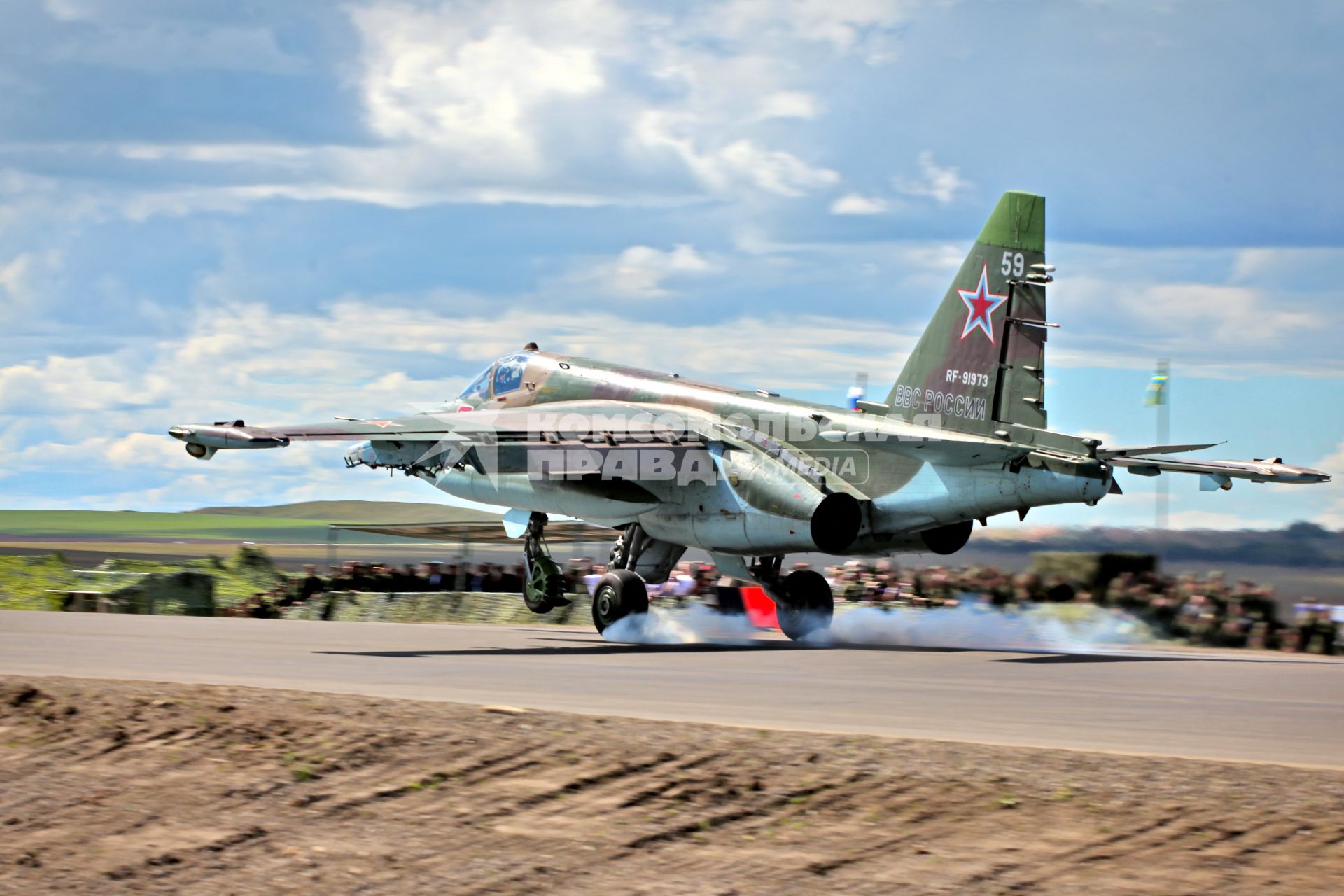 Военный штурмовик Су-25 `Грач` совершает посадку на автомобильную дорогу.