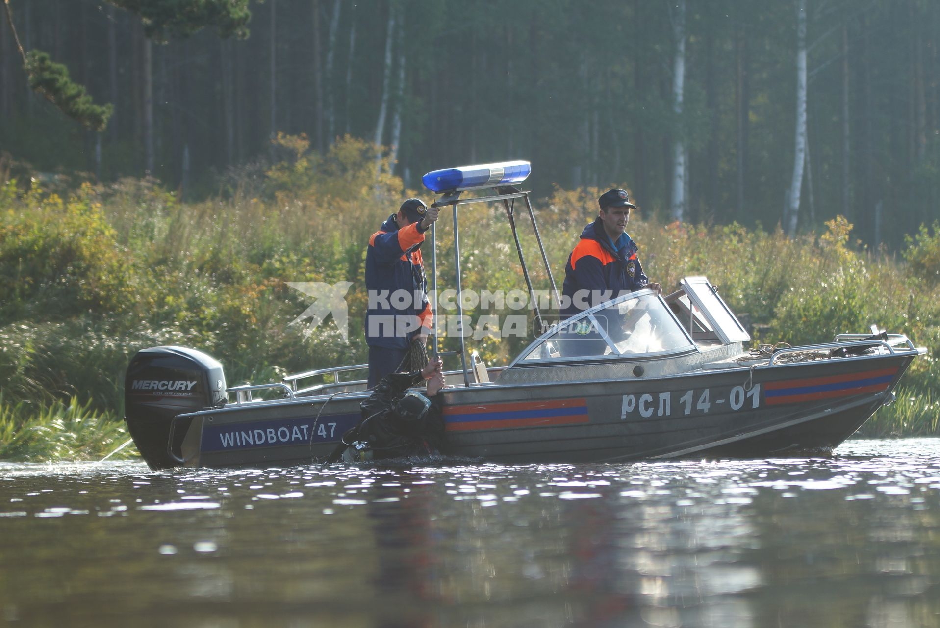 Водолаз держится за борт спасательного катера после поиска взрывчатки у плотины Волчихинского водохранилища. антитеррористические учения