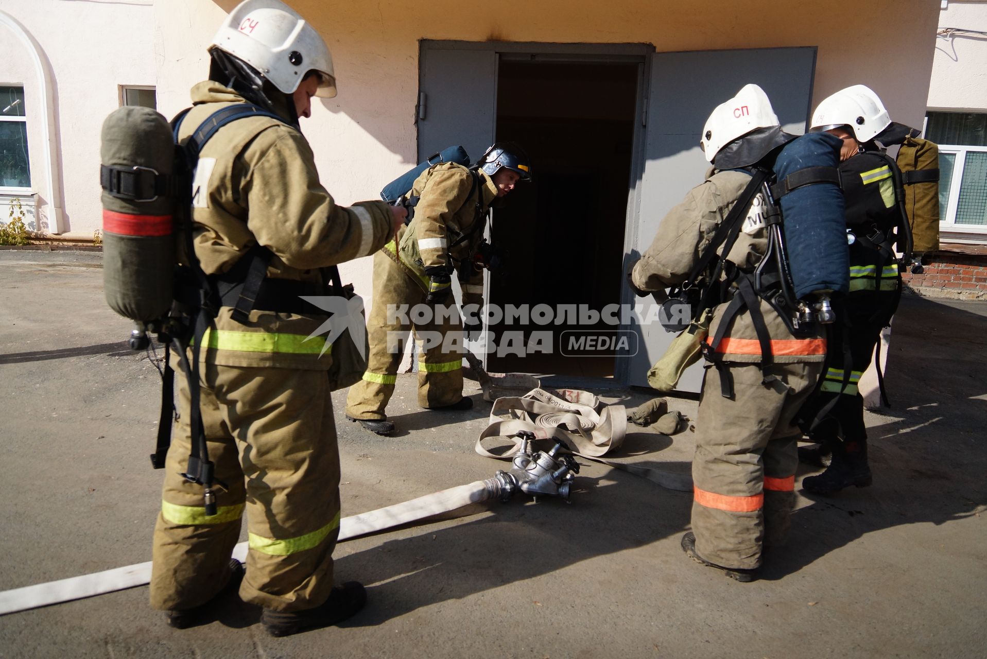 Пожарные разворачивают пожарные рукава перед входом в больницу. Пожарные учения в ГКБ №23 в Екатеринбурге