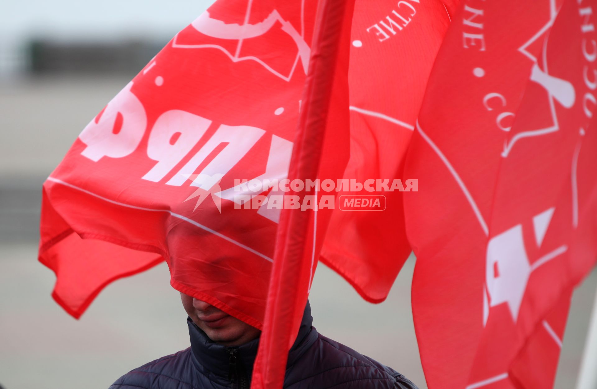 Крепостная горка, Ставрополь. Митинг КПРФ против повышения цен и тарифов ЖКХ. На фото: человек, которому красный флаг КПРФ закрывает лицо