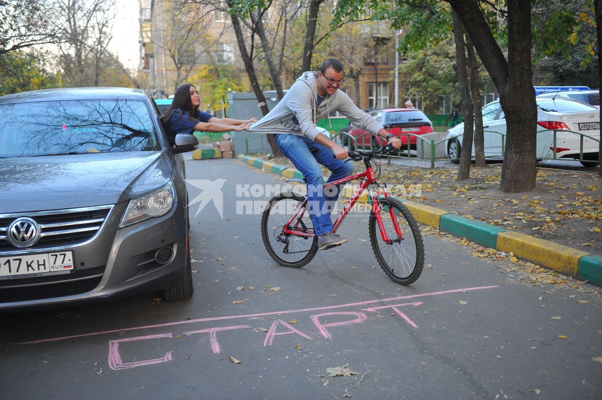 Девушка в автомобиле, мужчина на велосипеде.