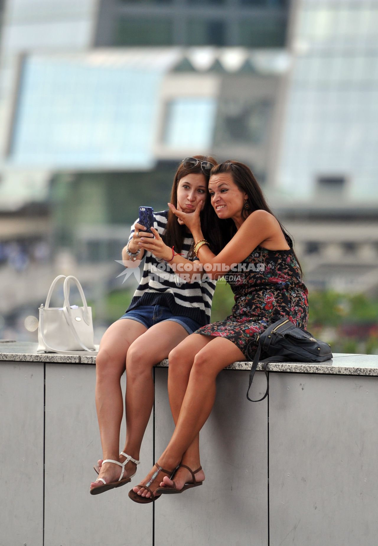 Девушки фотографируются на мобильный телефон.
