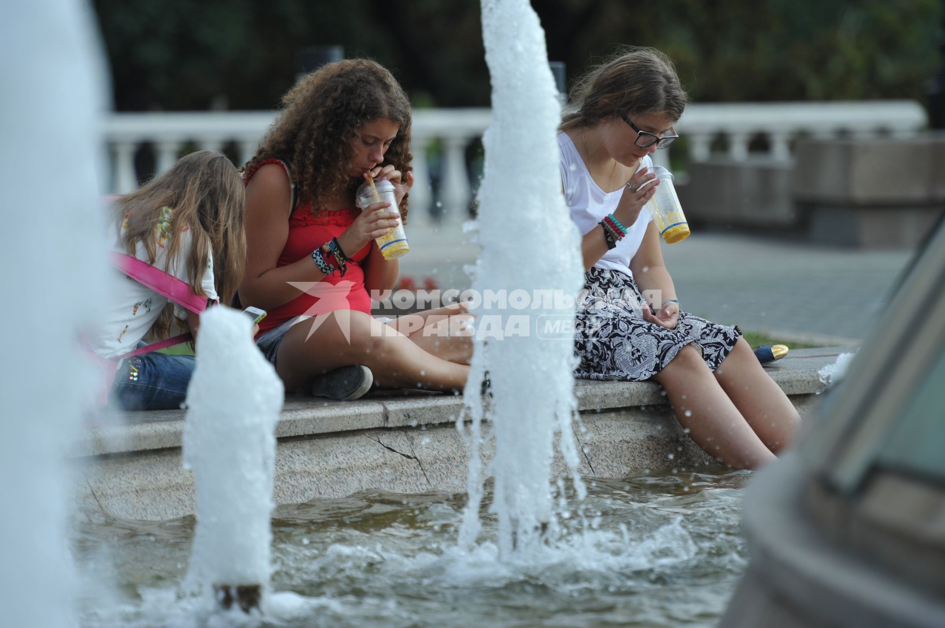 Манежная площадь. На снимке: девушки сидят у фонтана и пьют сок.