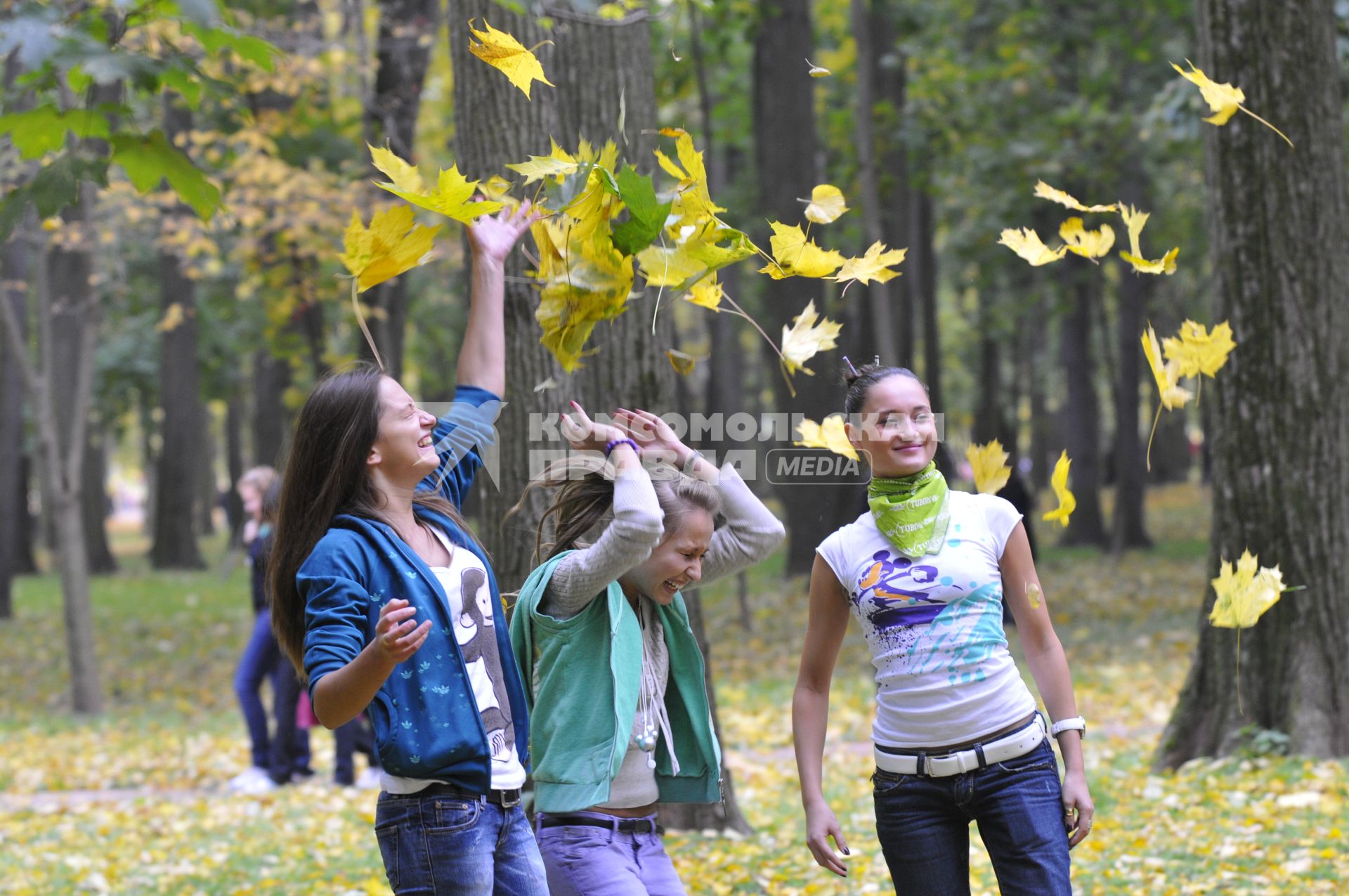 Осенний парк. На снимке: девушки кидают листья.